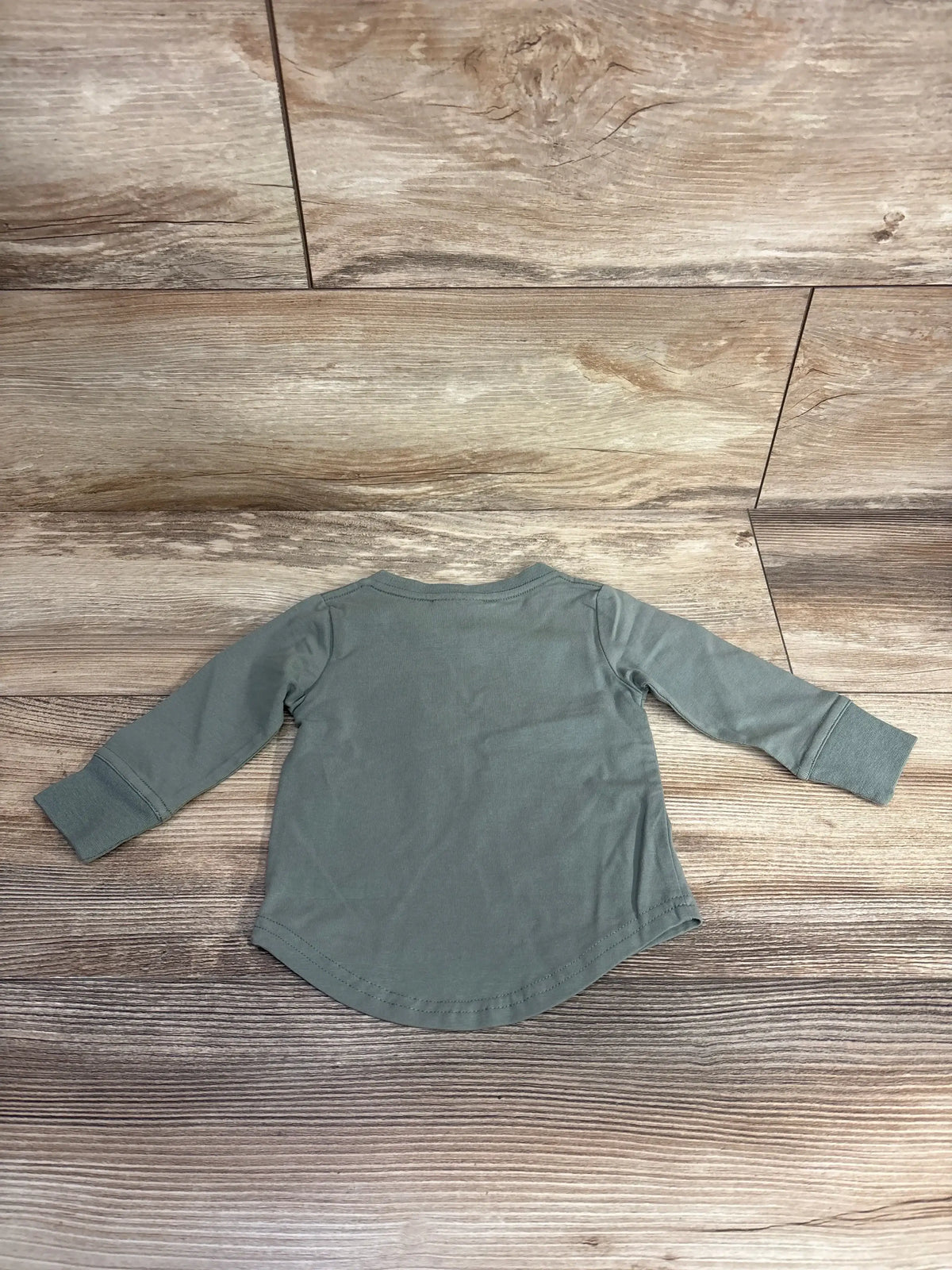 Back view of Little Bipsy newborn long sleeve tee size 0-3M showing curved hem and cuffed sleeves on wooden floor