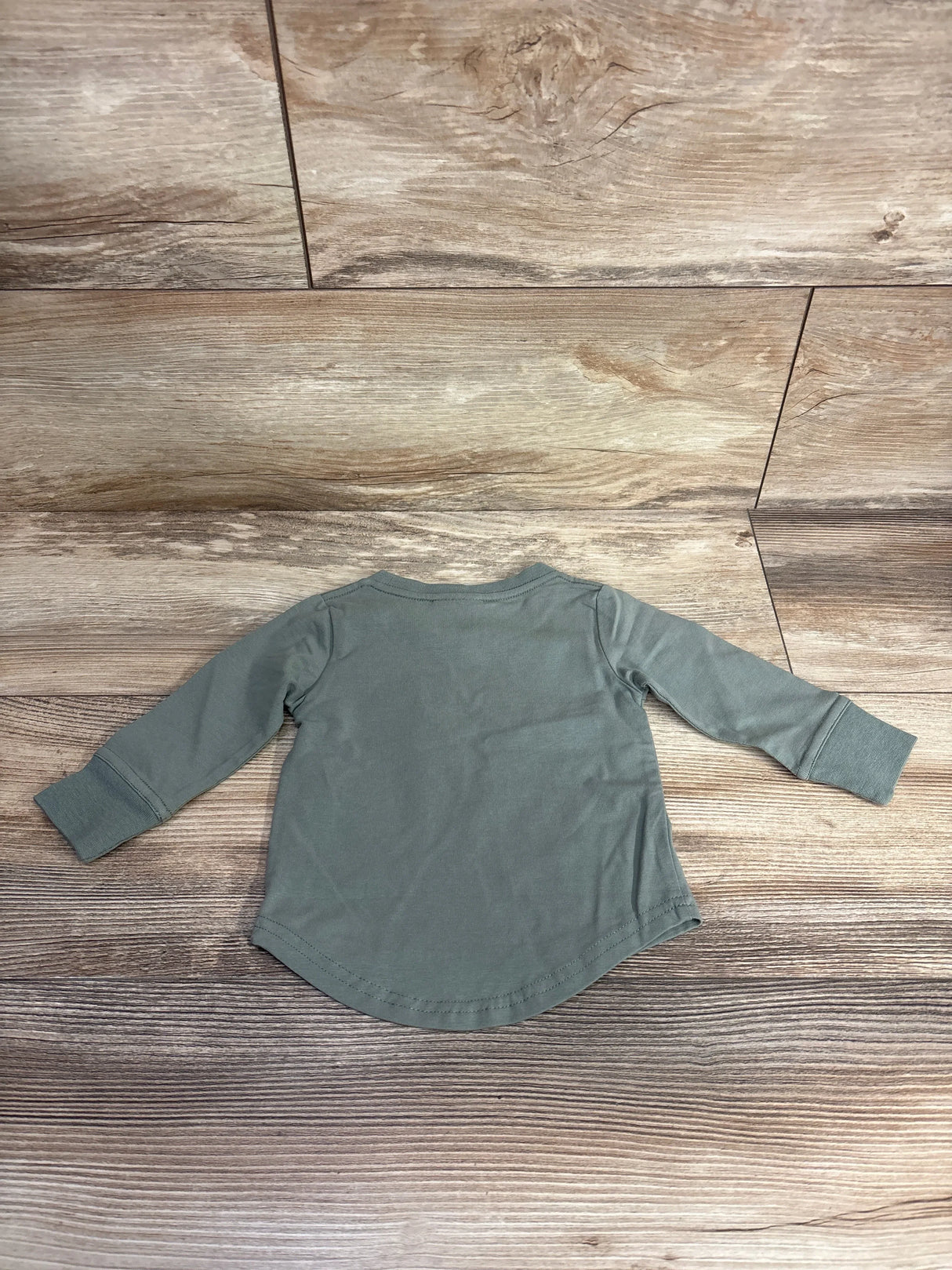 Back view of Little Bipsy newborn long sleeve tee size 0-3M showing curved hem and cuffed sleeves on wooden floor