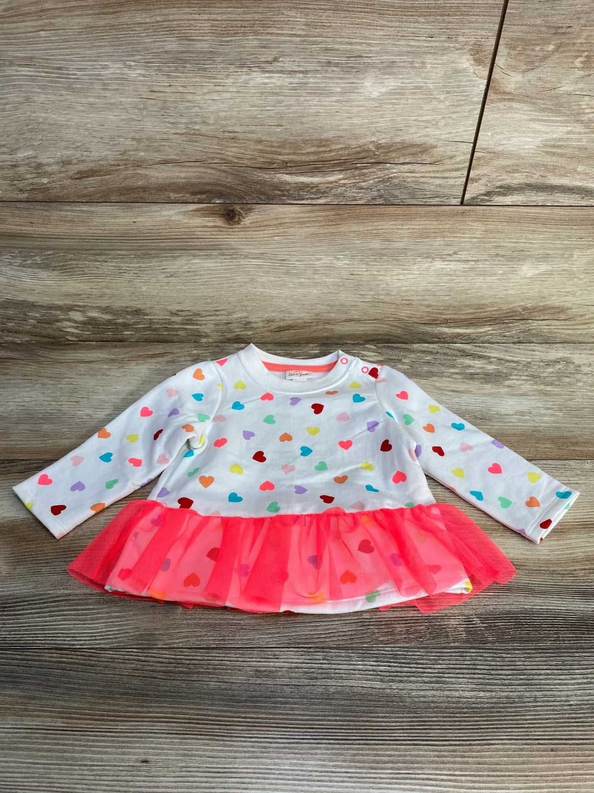 Front view of Cat & Jack baby heart-print sweatshirt (6–9 months) showcasing multicolor hearts and neon pink tulle ruffle on rustic wood background