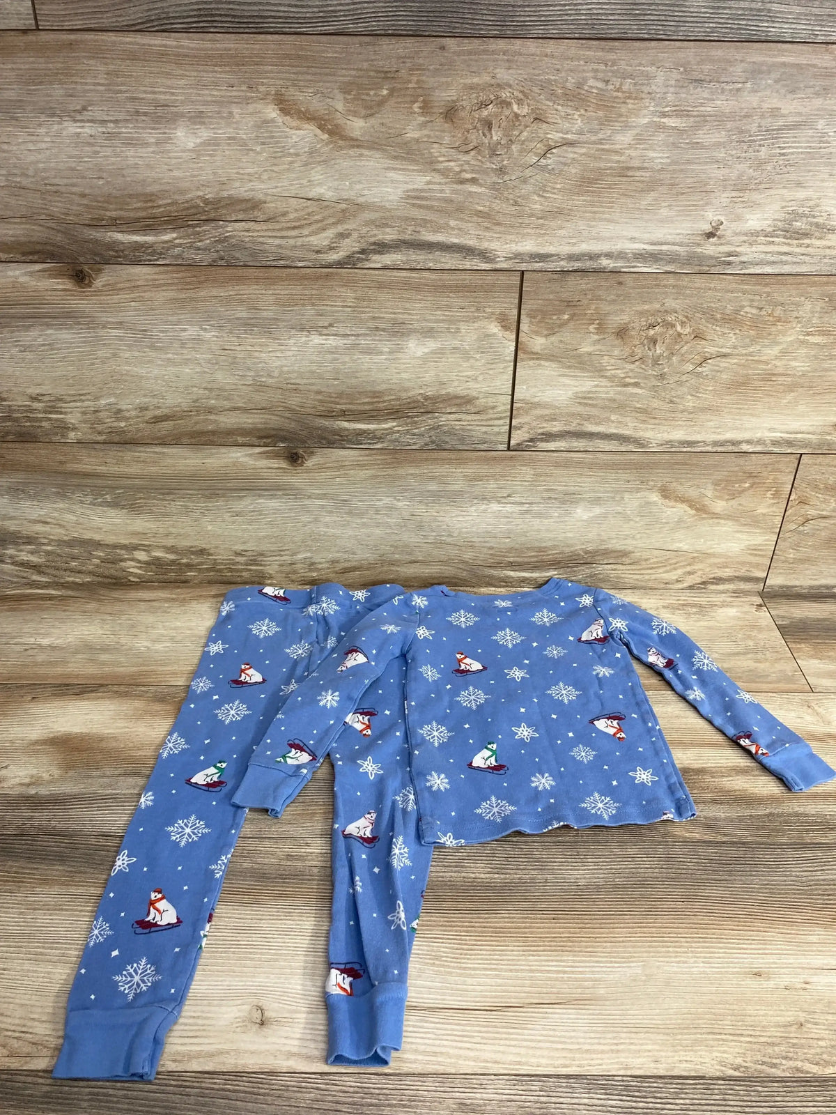 Blue kids winter pajamas set with polar bear and snowflake print on wooden floor