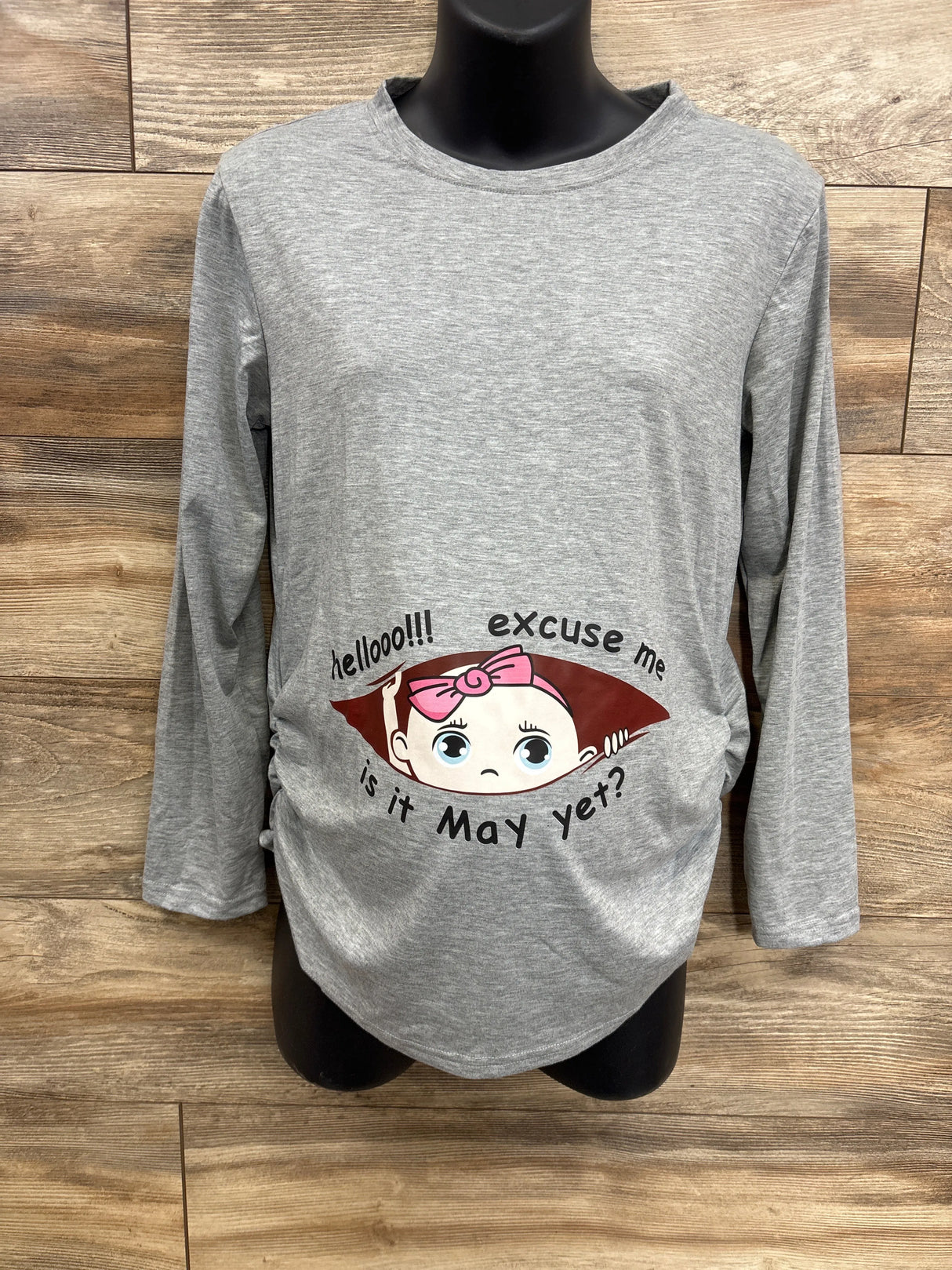 Gray maternity shirt with cartoon baby graphic and text, long sleeves, displayed on mannequin
