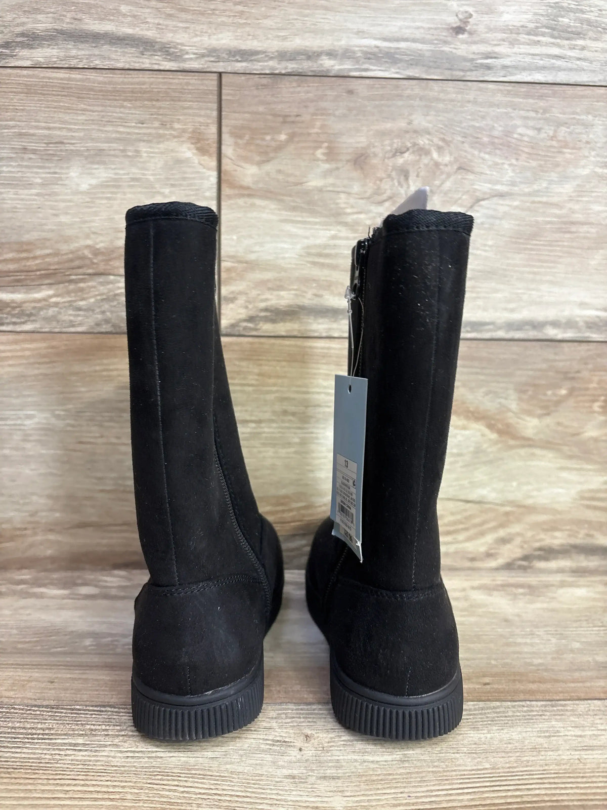 Black suede kids boots with zipper, displayed on wood floor, resale store product