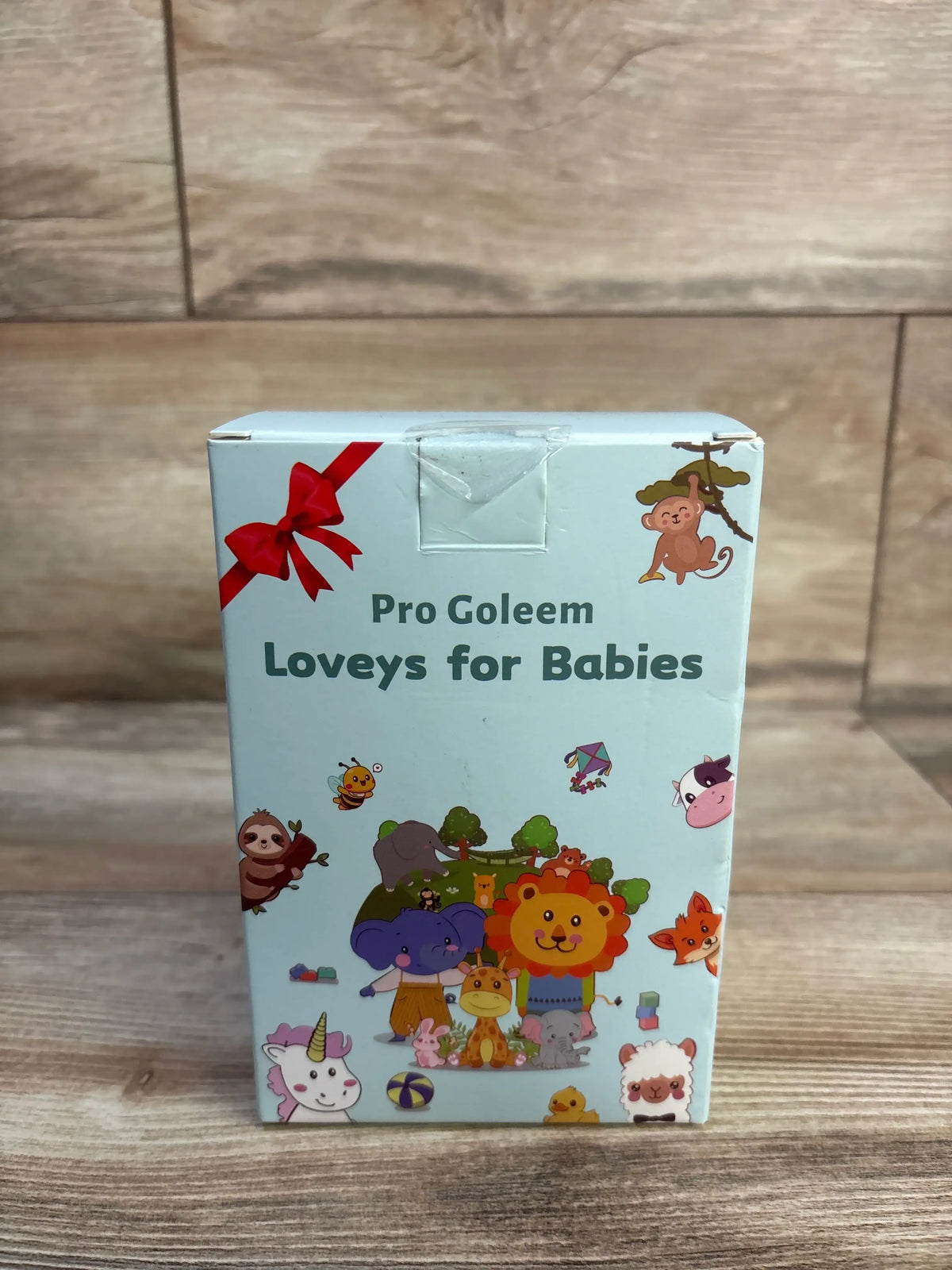Front view of the Pro Goleem elephant security blanket package with colorful animal illustrations on a wood surface