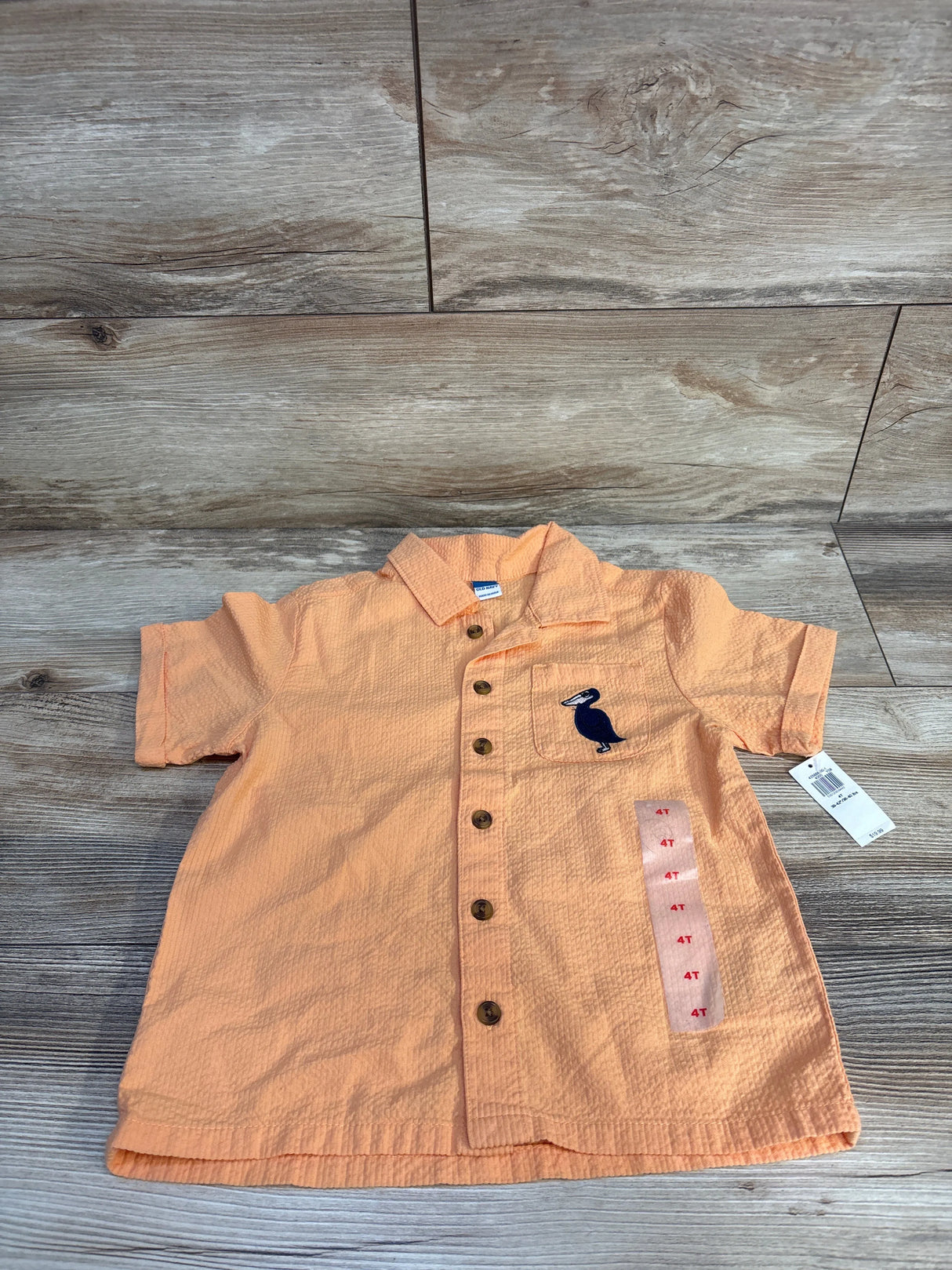 Front view of orange Old Navy crinkle gauze button-up shirt, size 4T, with short sleeves, chest patch pocket, and buttons