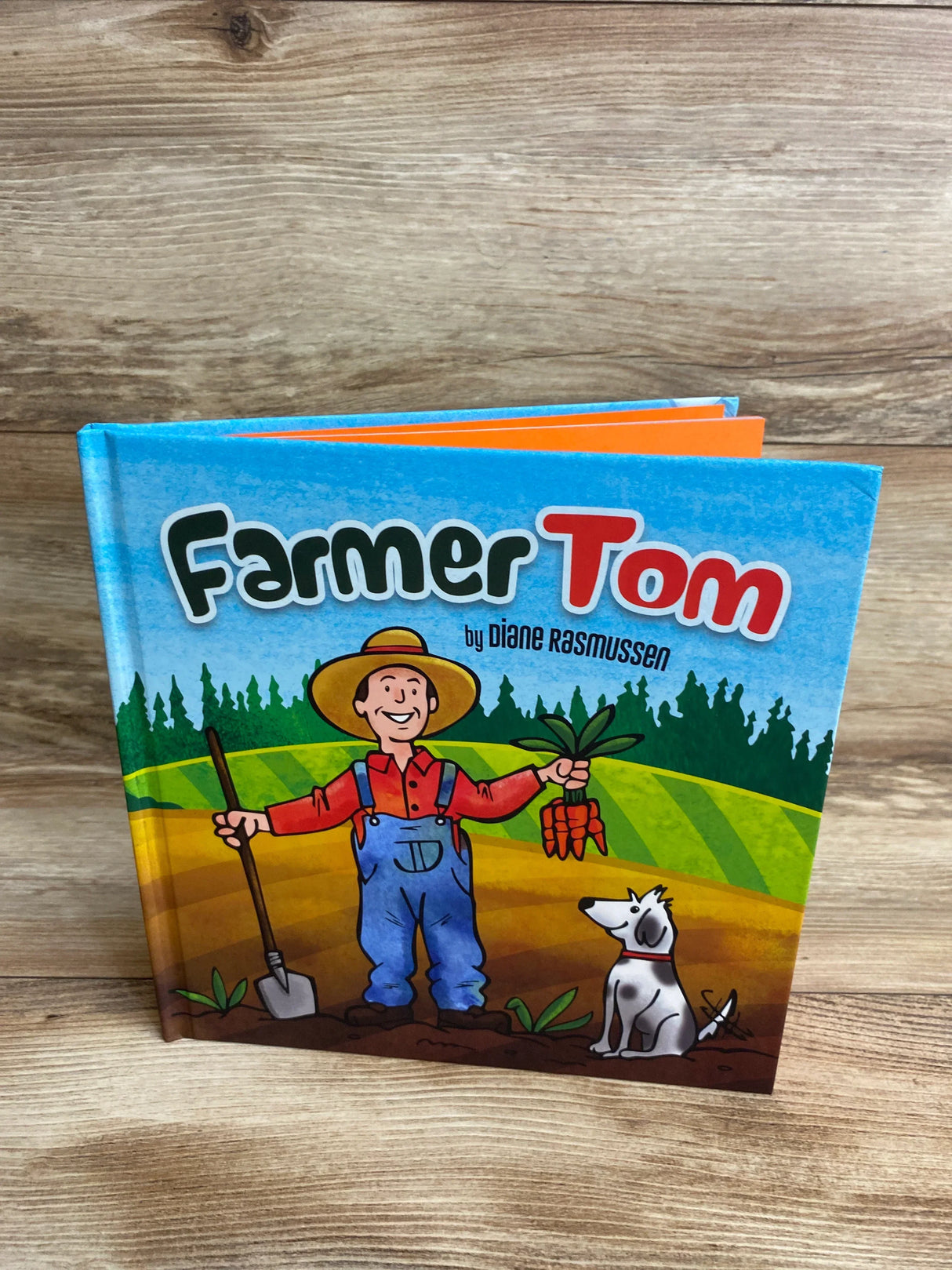 Children's book Farmer Tom cover featuring cartoon farmer with carrots and dog on a farm