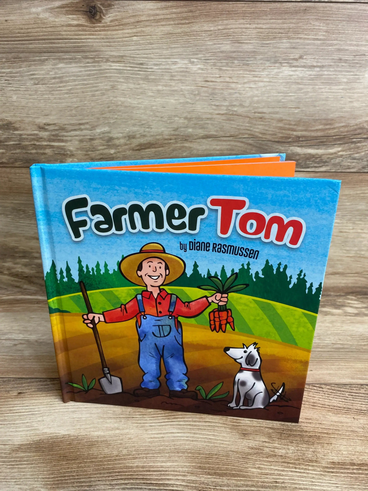 Children's book Farmer Tom cover featuring cartoon farmer with carrots and dog on a farm