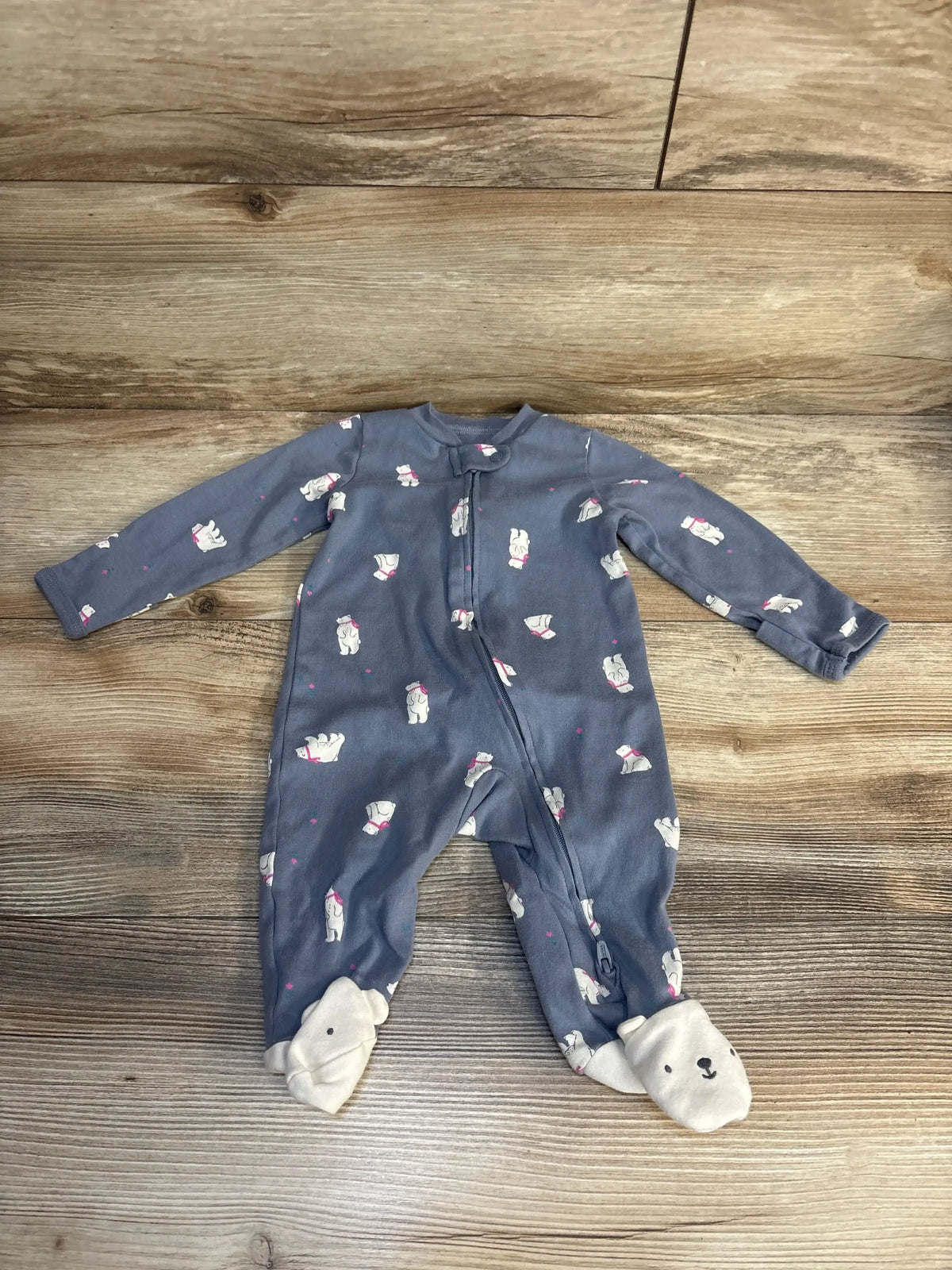 Gray baby sleeper with polar bear print and bear face footies on wood background