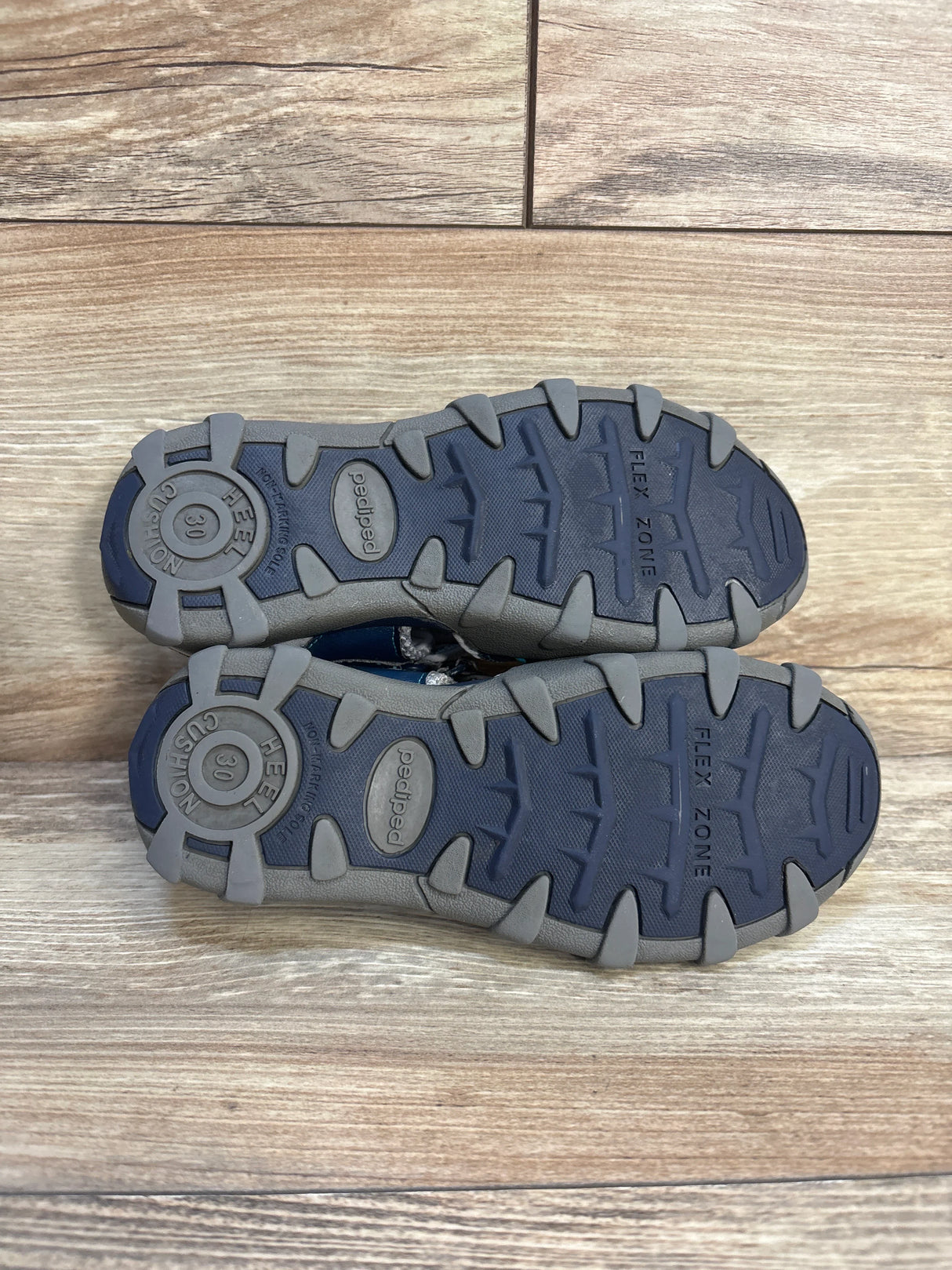 Pair of kids' blue and grey pediped shoes with non-slip soles on wood floor