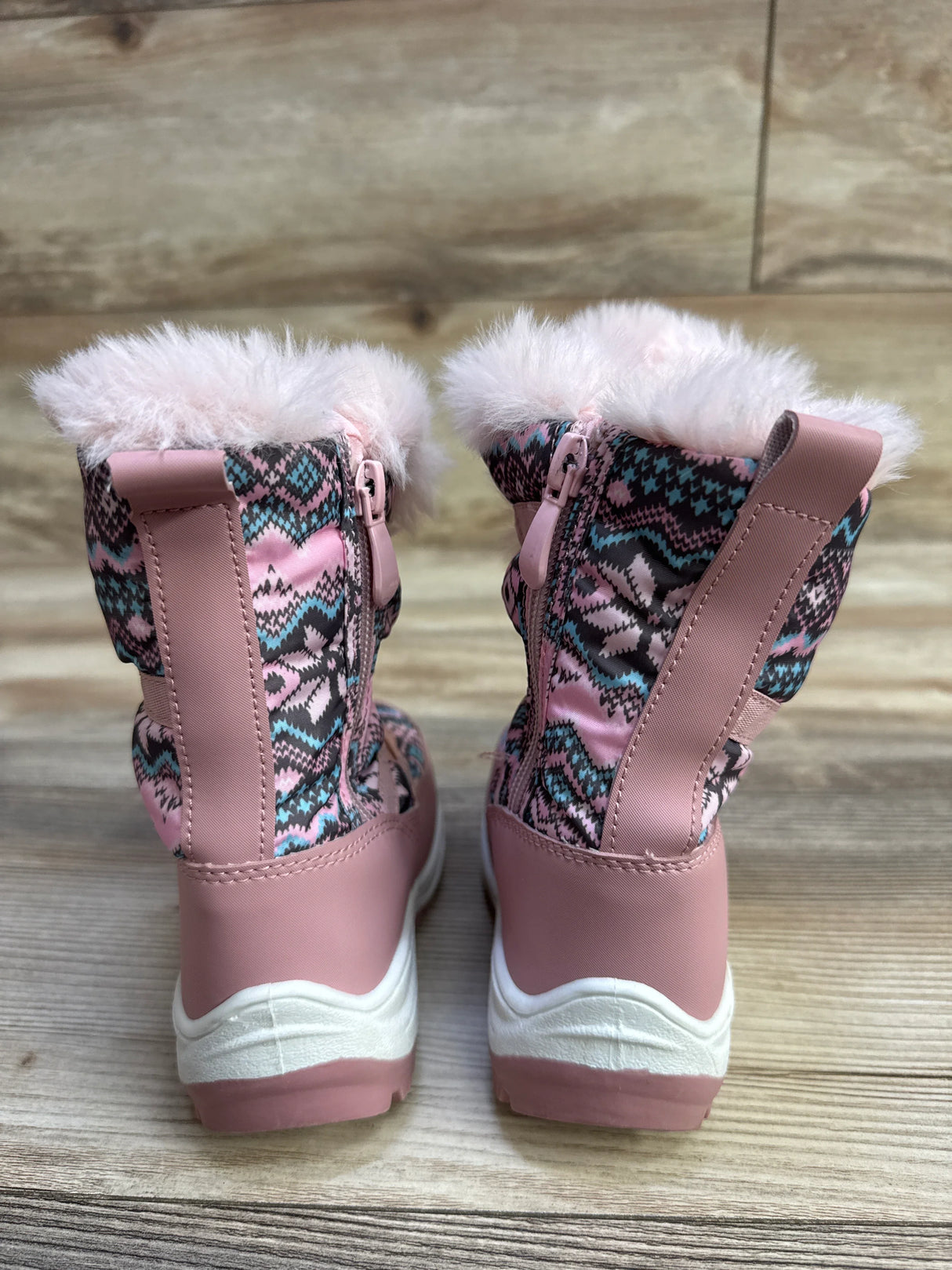 Rear view of Nova Mountain toddler snow boots, pink patterned upper, faux-fur cuff, side zipper, white sole on wood floor