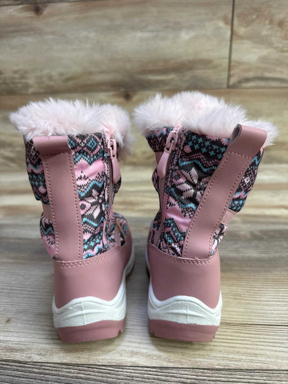Rear view of Nova Mountain toddler snow boots, pink patterned upper, faux-fur cuff, side zipper, white sole on wood floor