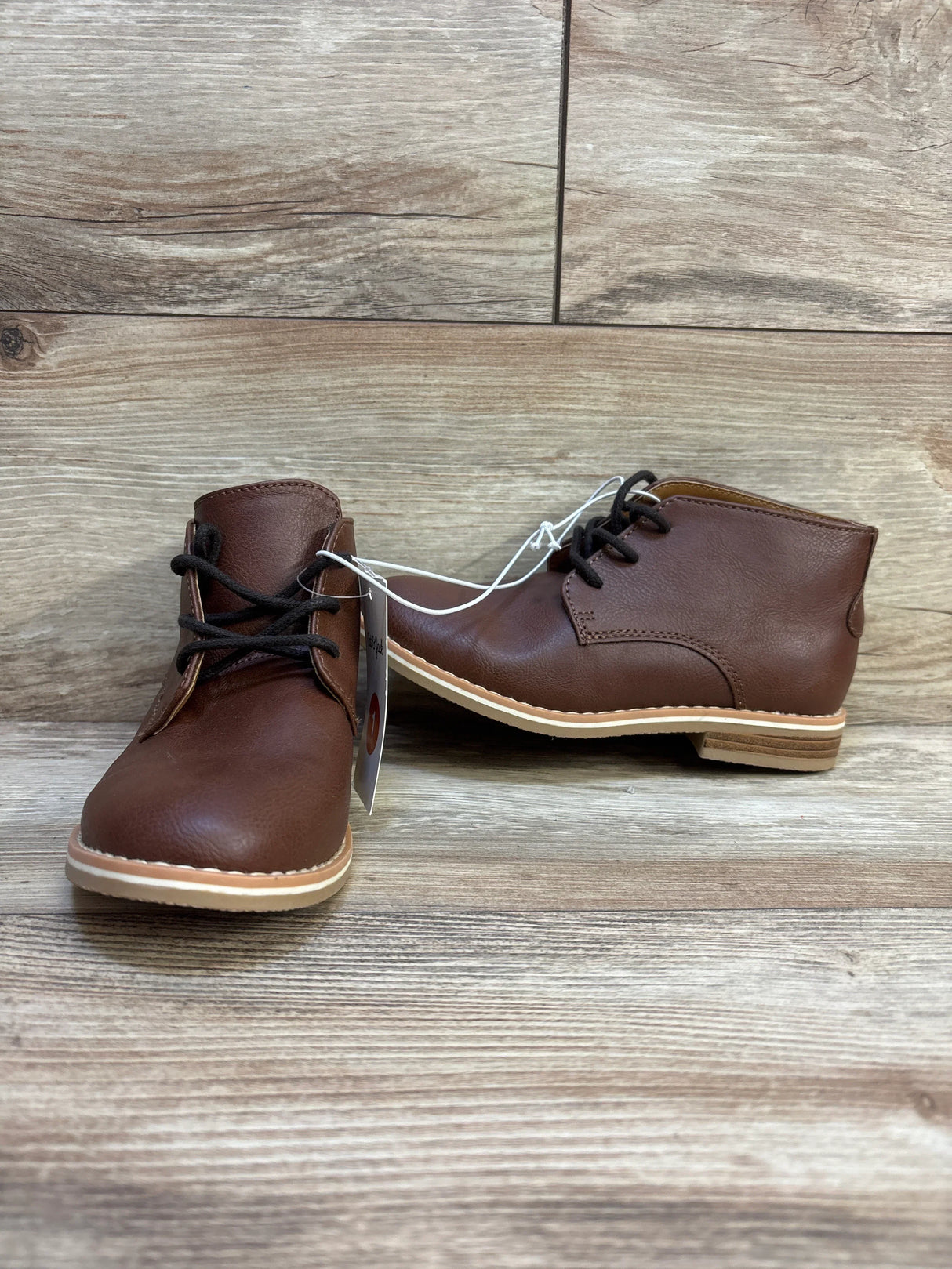 Front and side view of Cat and Jack brown toddler lace-up boots showing black laces and tan sole on wood background