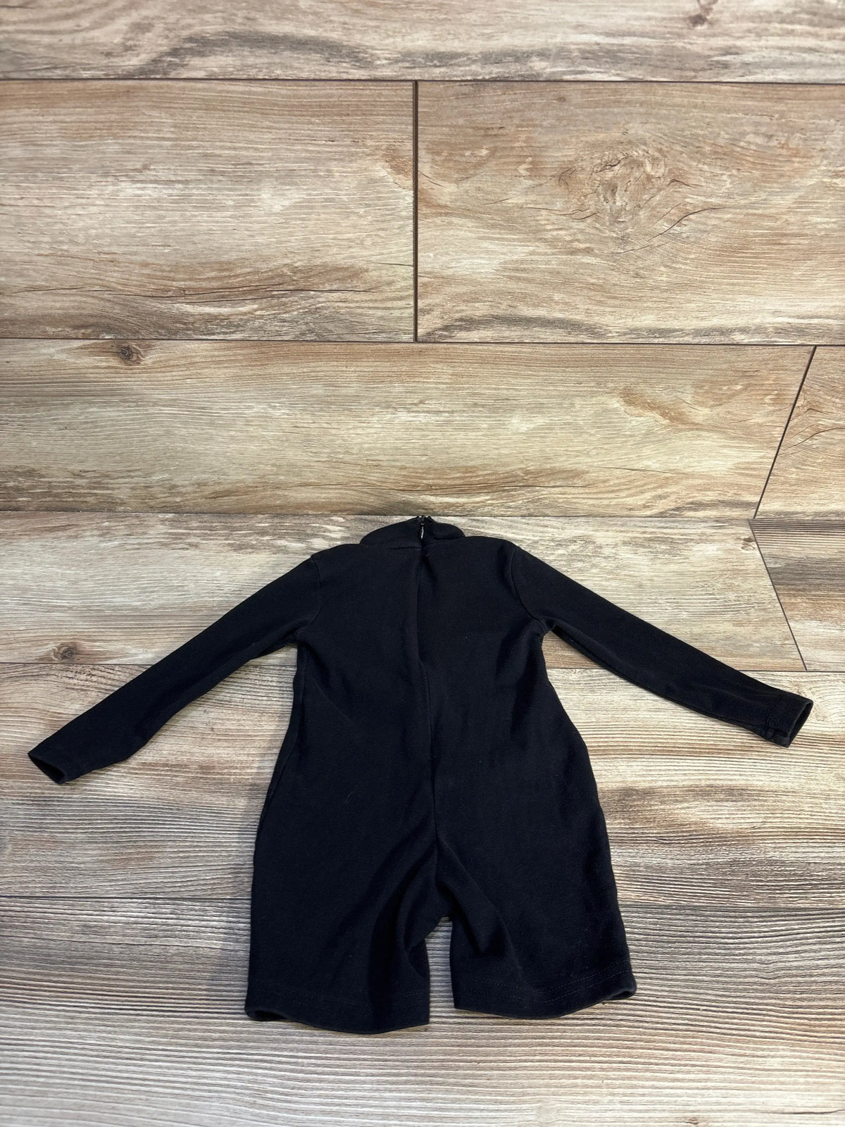 Back view of Shein long sleeve dragon shortie romper in black, showcasing long sleeves and shortie length on wood-look flooring