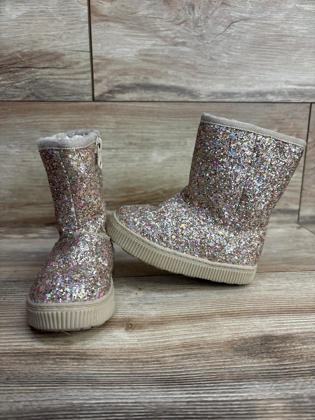 Front and side of Cat & Jack Holland shearling toddler boots, glitter exterior, faux-shearling cuff, beige sole on wood