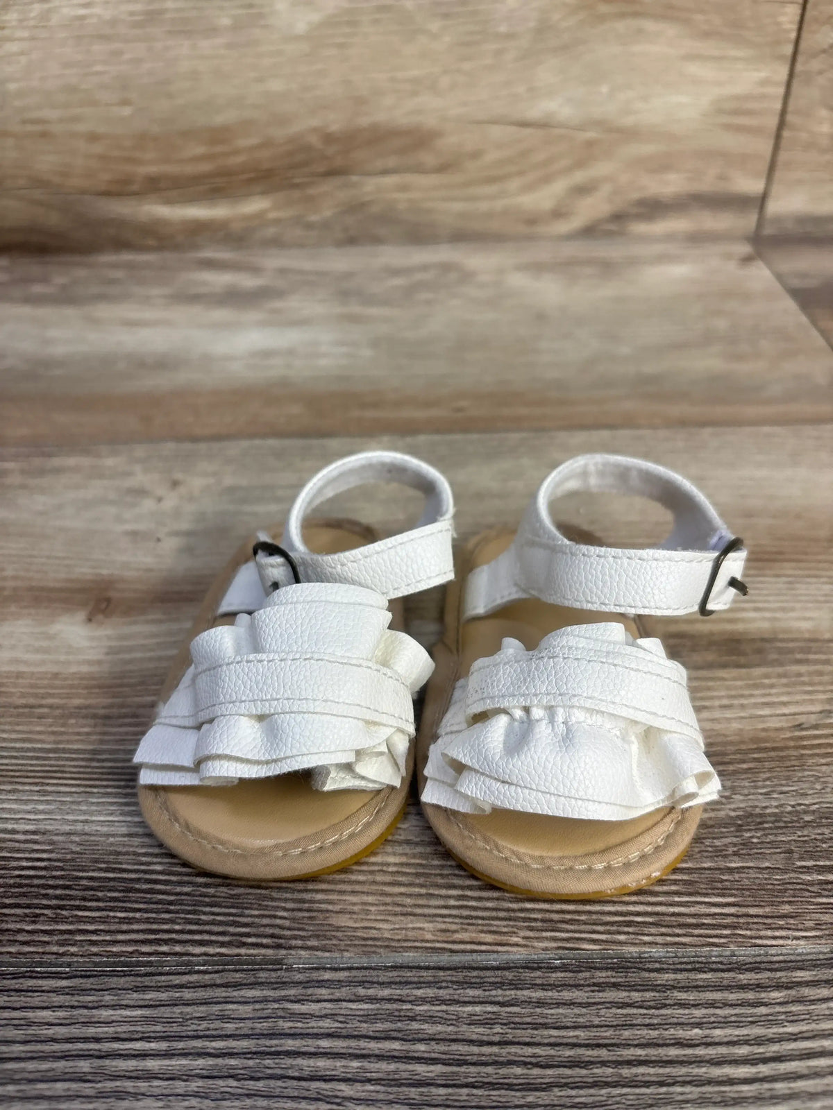 Front view of white Muchenggift bowknot soft sole sandals showcasing layered straps and ankle straps on a wood floor