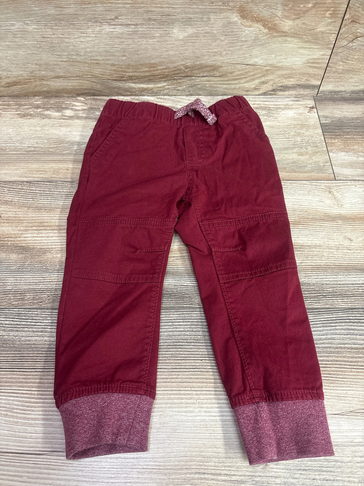 Cat & Jack red drawstring cotton joggers for toddlers, size 2T, on a light wood background.