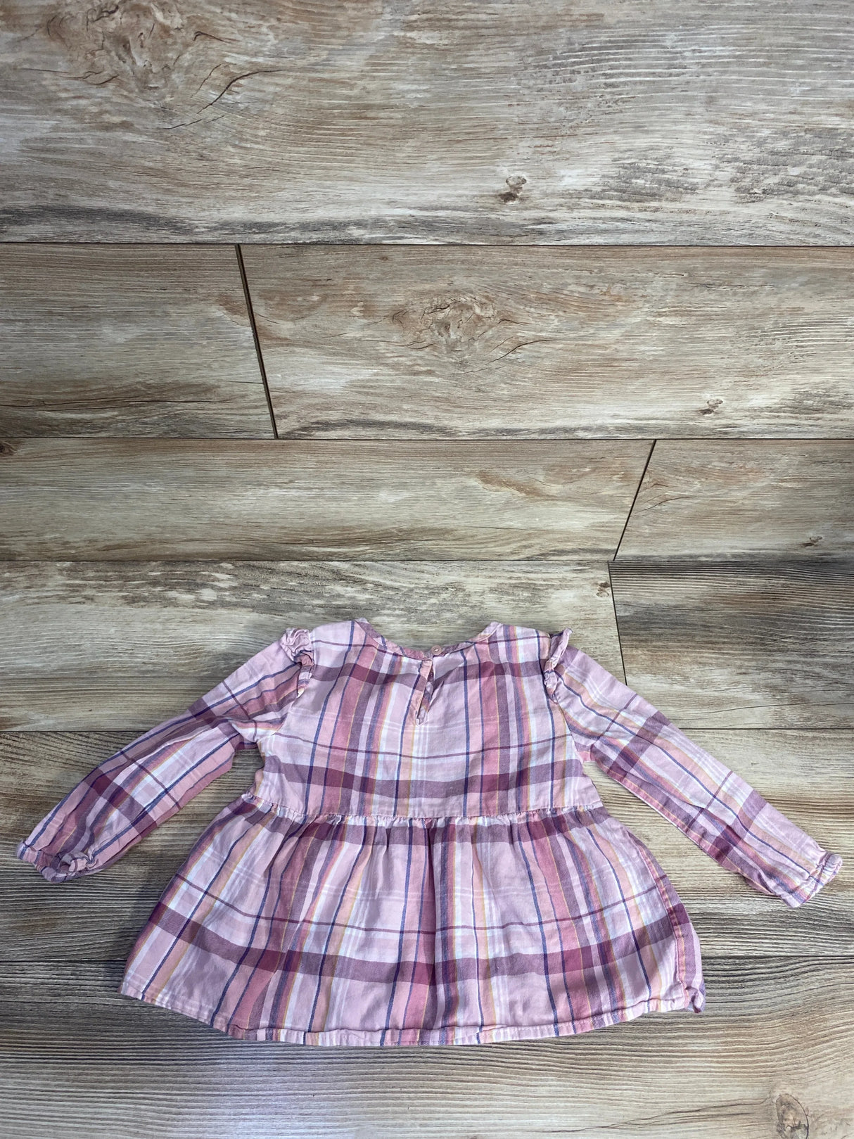 Pink and purple plaid long-sleeve toddler dress with gathered waist on wooden floor