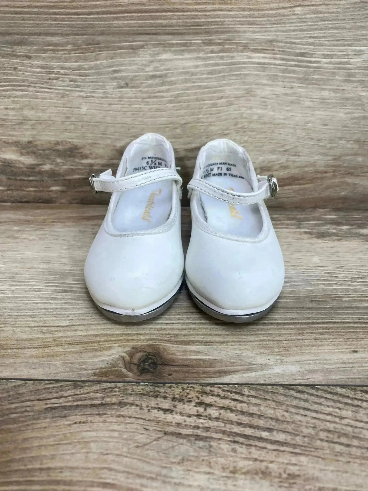 Front view of Theatricals tap buckle shoes showing Mary Jane strap and metal tap plates on wooden floor background