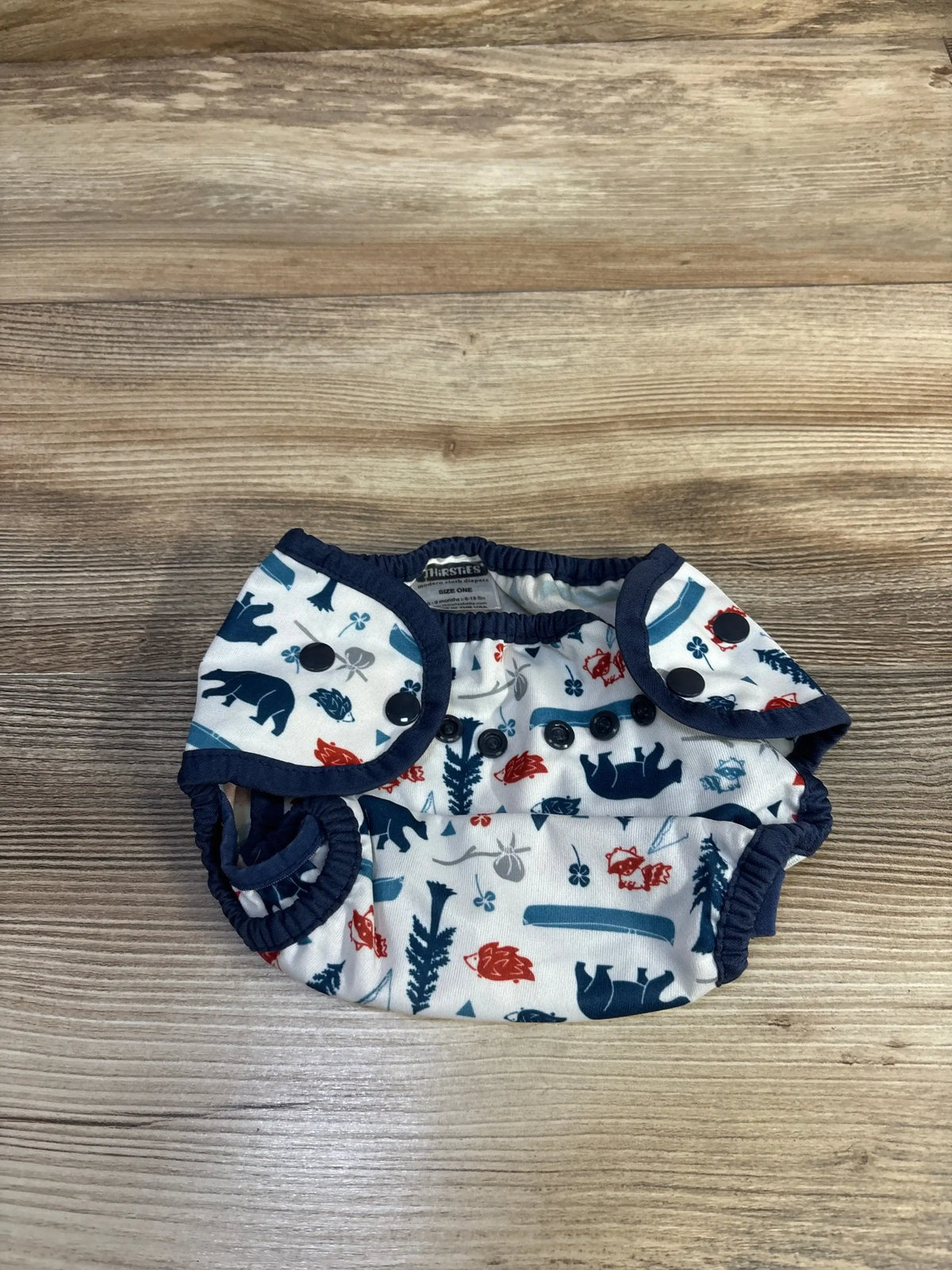 Front view of Thirsties swim diaper, white, showing elasticized leg openings and adjustable snap waist on white background