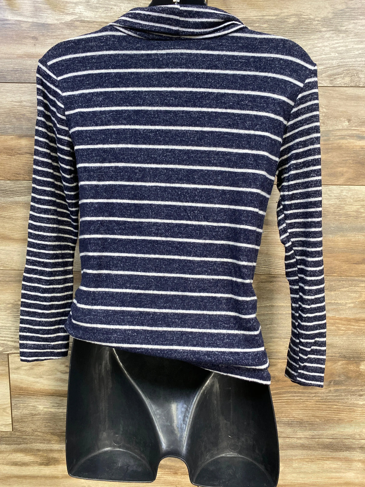 Navy blue and white striped long sleeve shirt on mannequin, wood background