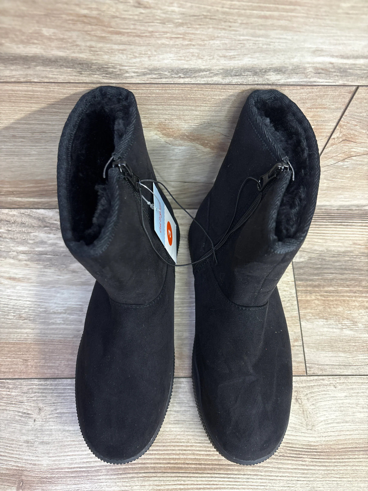 Pair of black kids winter boots with fuzzy lining and side zipper on wood floor, children's resale store