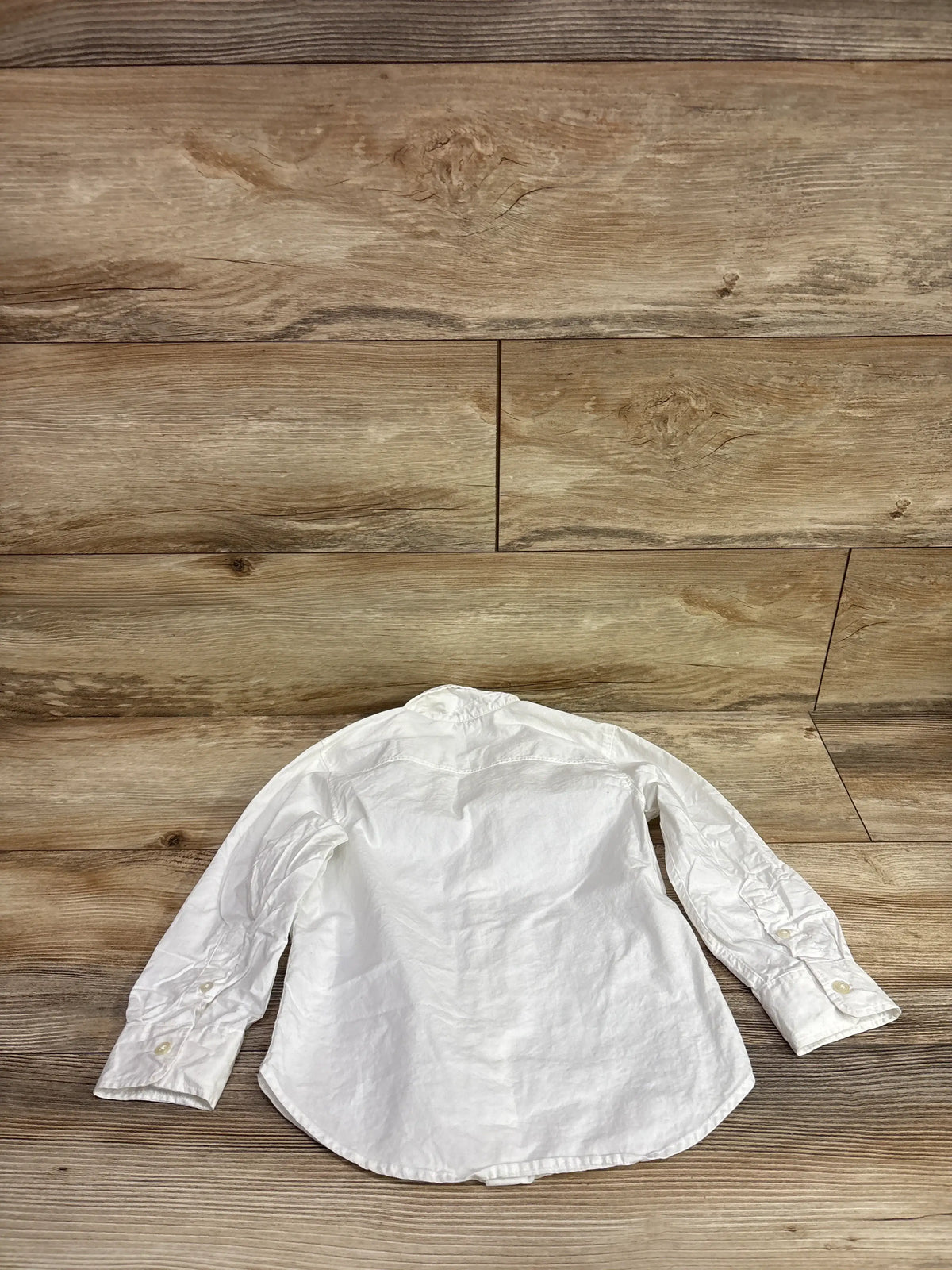 H&M white long sleeve button up shirt for toddlers size 4T on a wood background