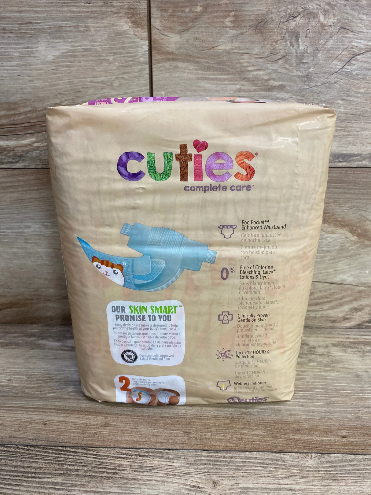 Cuties Complete Care baby diapers pack on wooden floor, front and features visible