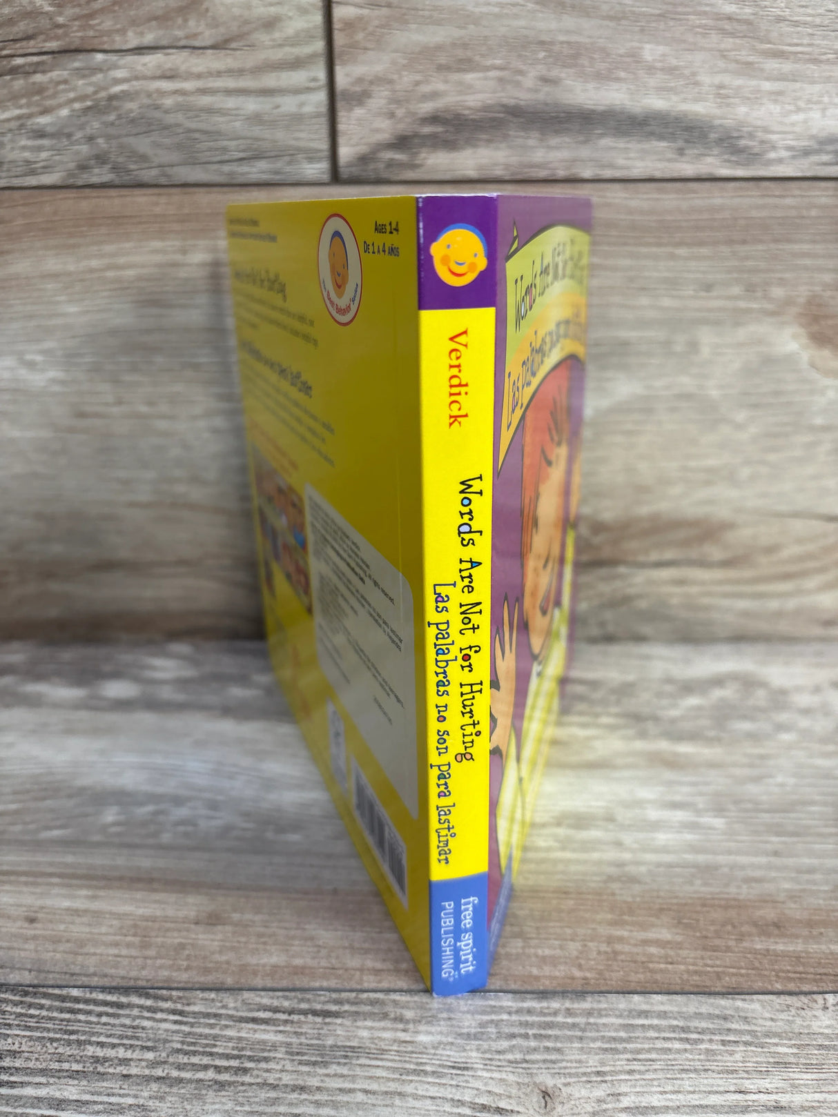 Words Are Not for Hurting bilingual children's book by Verdick, standing on wood floor