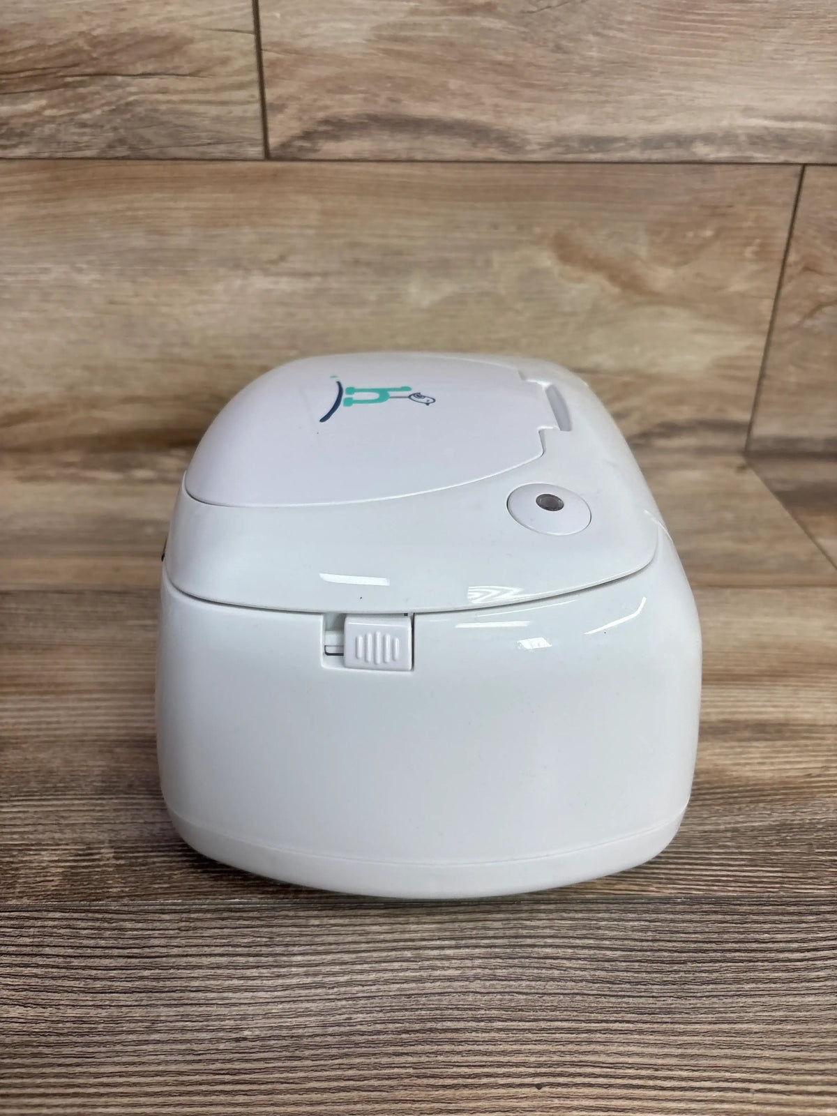 Front view of Hiccapop Ultra Wipe Warmer in white showcasing front slider latch and top lid on a wood tabletop background