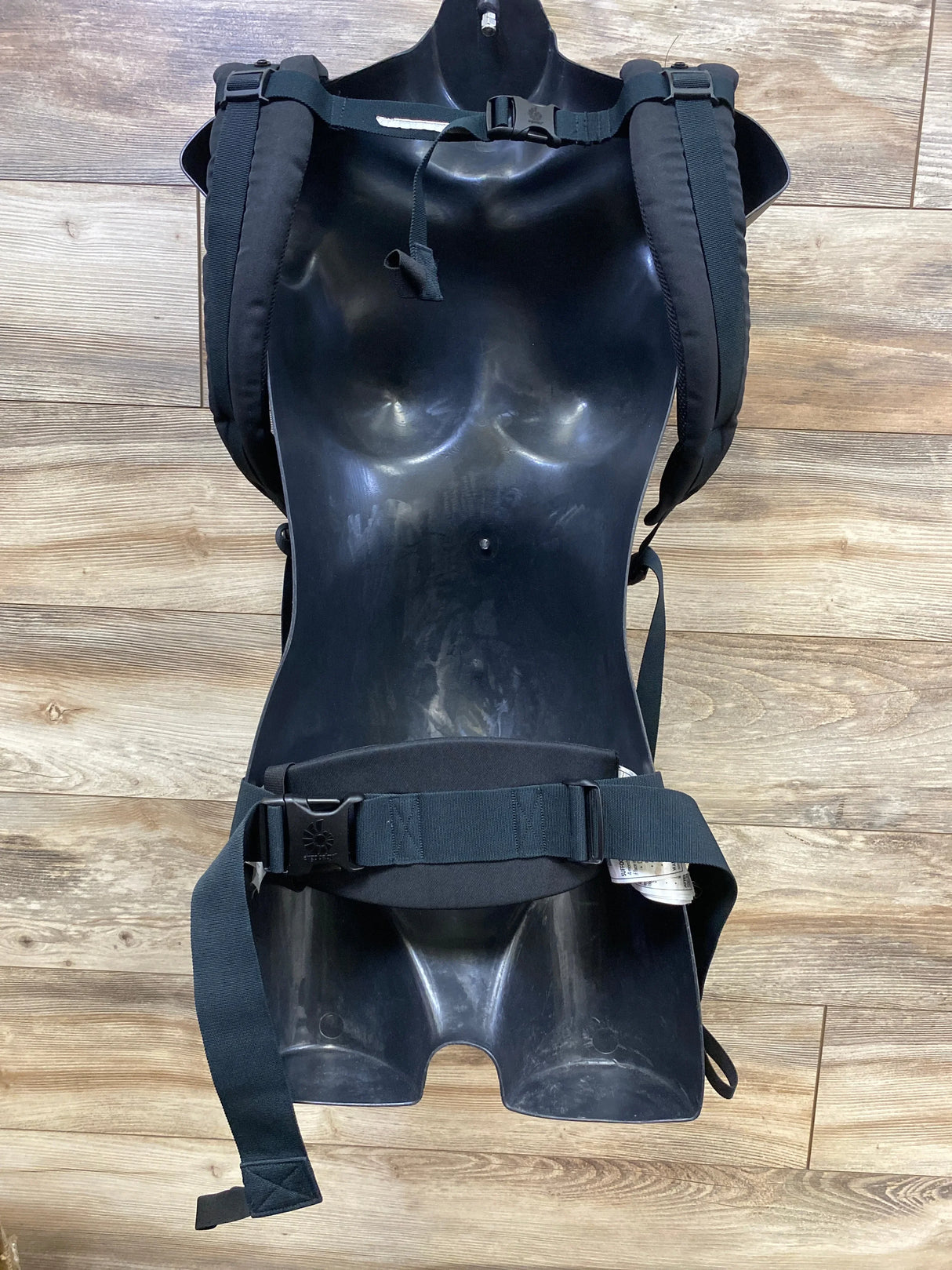Front view of Ergobaby Adapt Cool Air Mesh carrier in onyx black showing padded straps and waist belt on wood floor