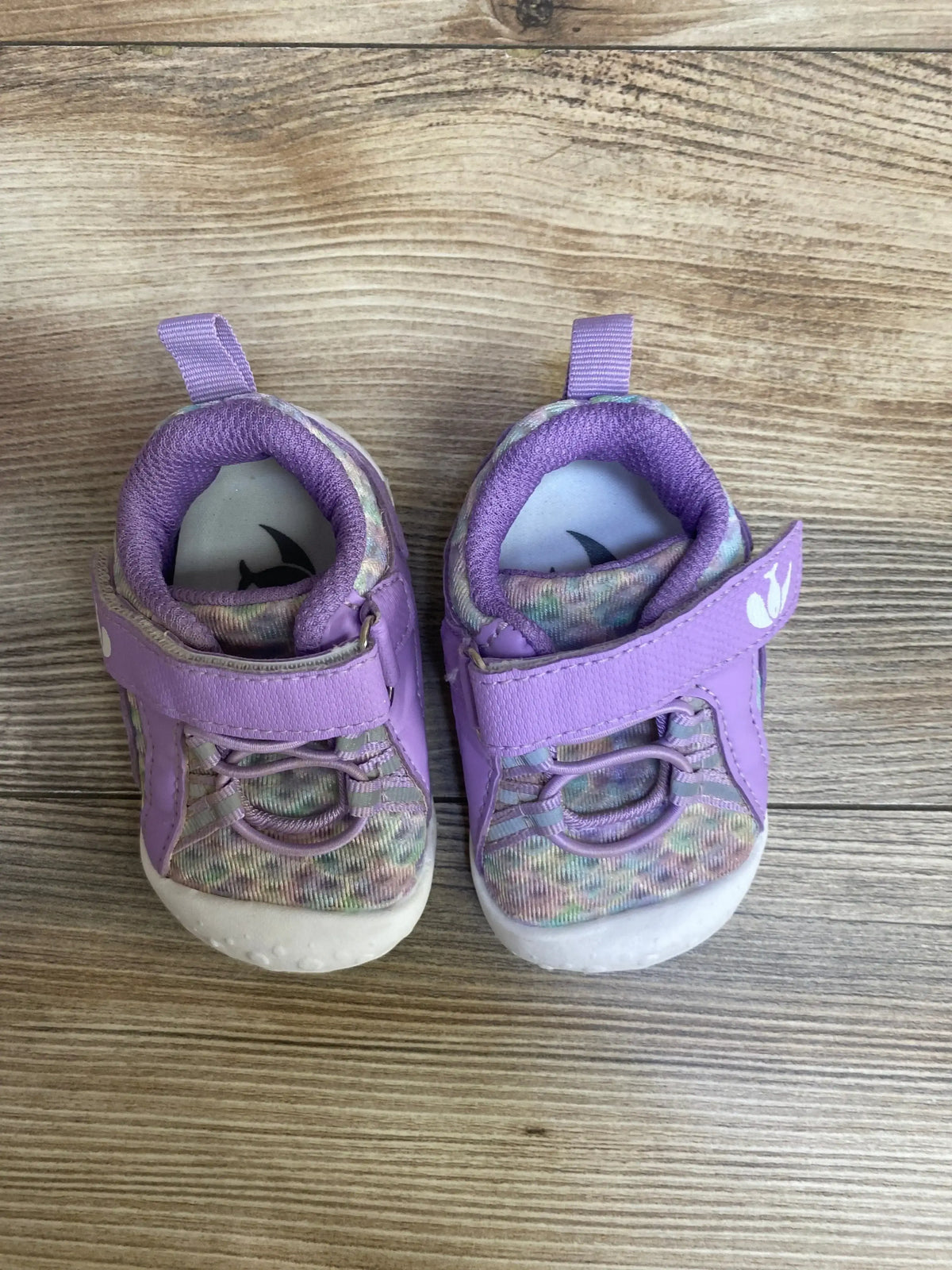 Top view of FEETCITY wide barefoot toddler water shoes, purple, showing Velcro strap and patterned mesh upper on wood floor