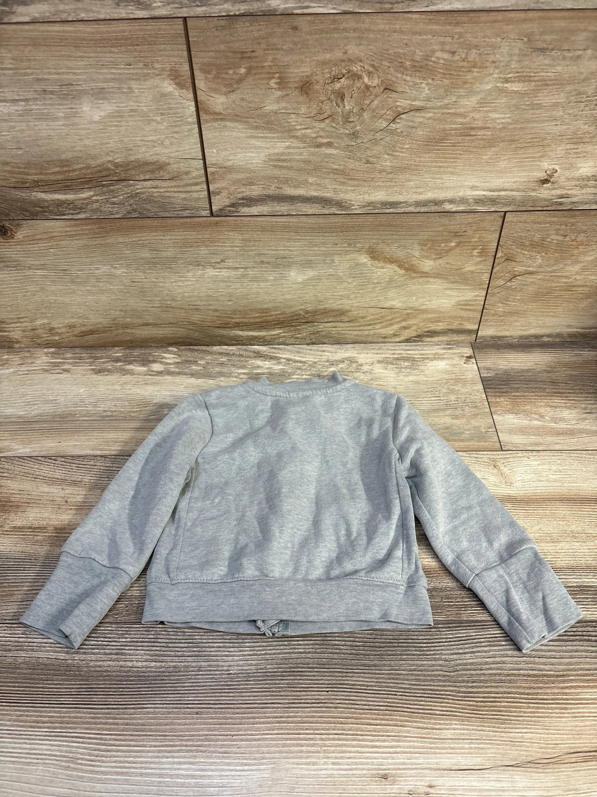 Back view of Hanes zip-up toddler sweatshirt showcasing long sleeves and ribbed cuffs with wood plank background