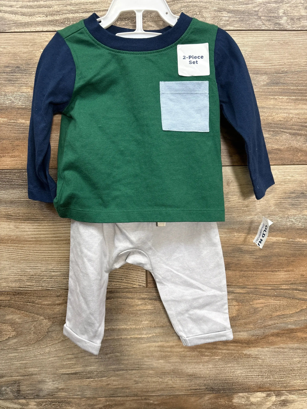 Baby boy 2-piece outfit with green and navy long sleeve top, light blue pocket, and white pants