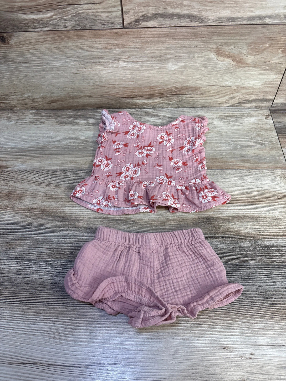 Flat lay of Cat & Jack gauze peplum top and shorts set showcasing floral print and ruffled hems on a wood-grain background