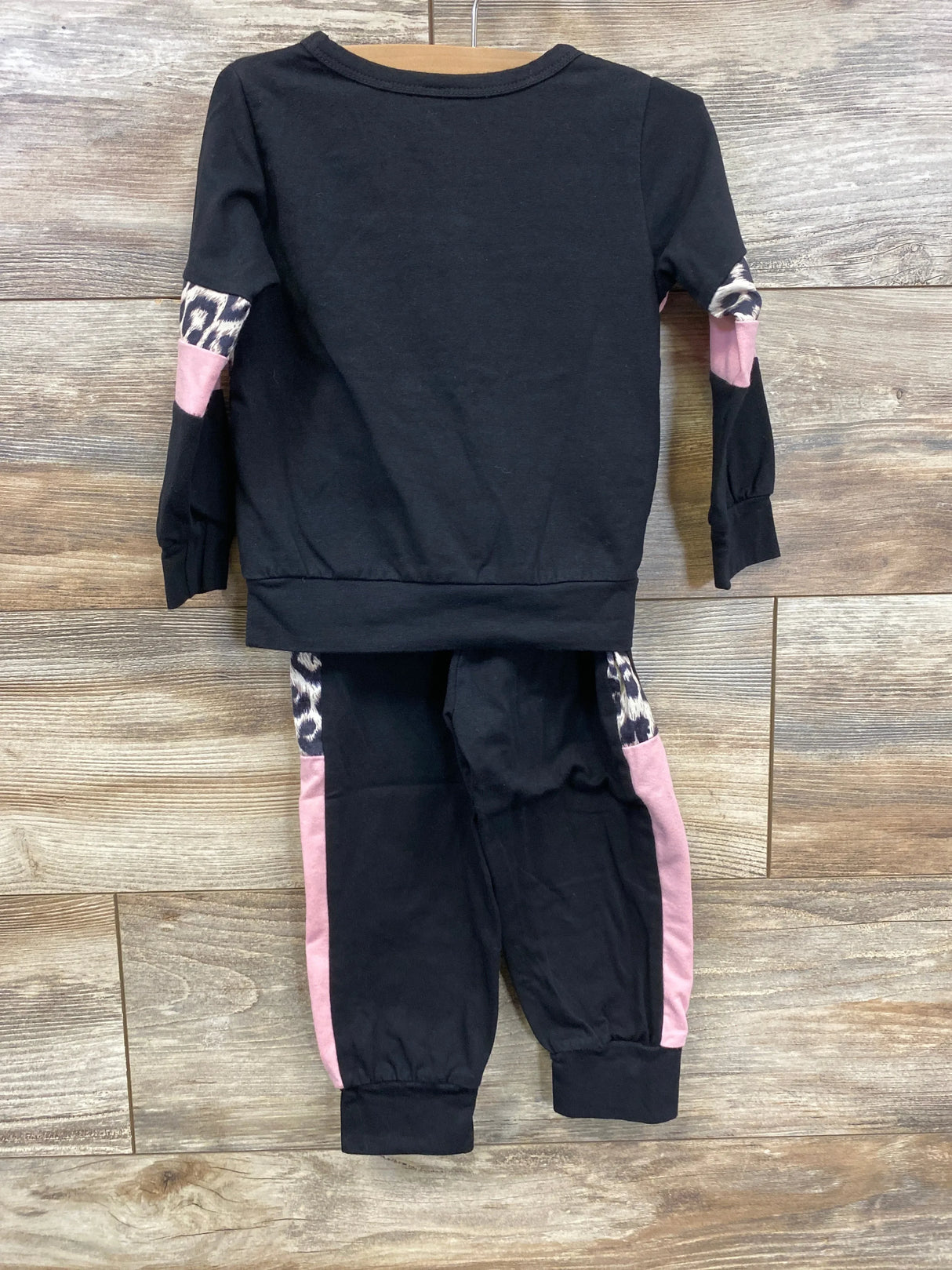 Black toddler outfit set with pink and leopard print accents on arms and pant legs, flat lay