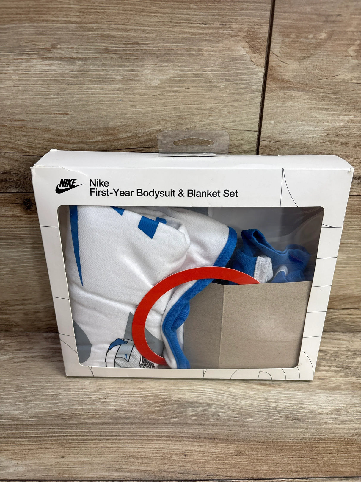 Nike First-Year Bodysuit & Blanket Set in white and blue, packaged in a white box with clear window
