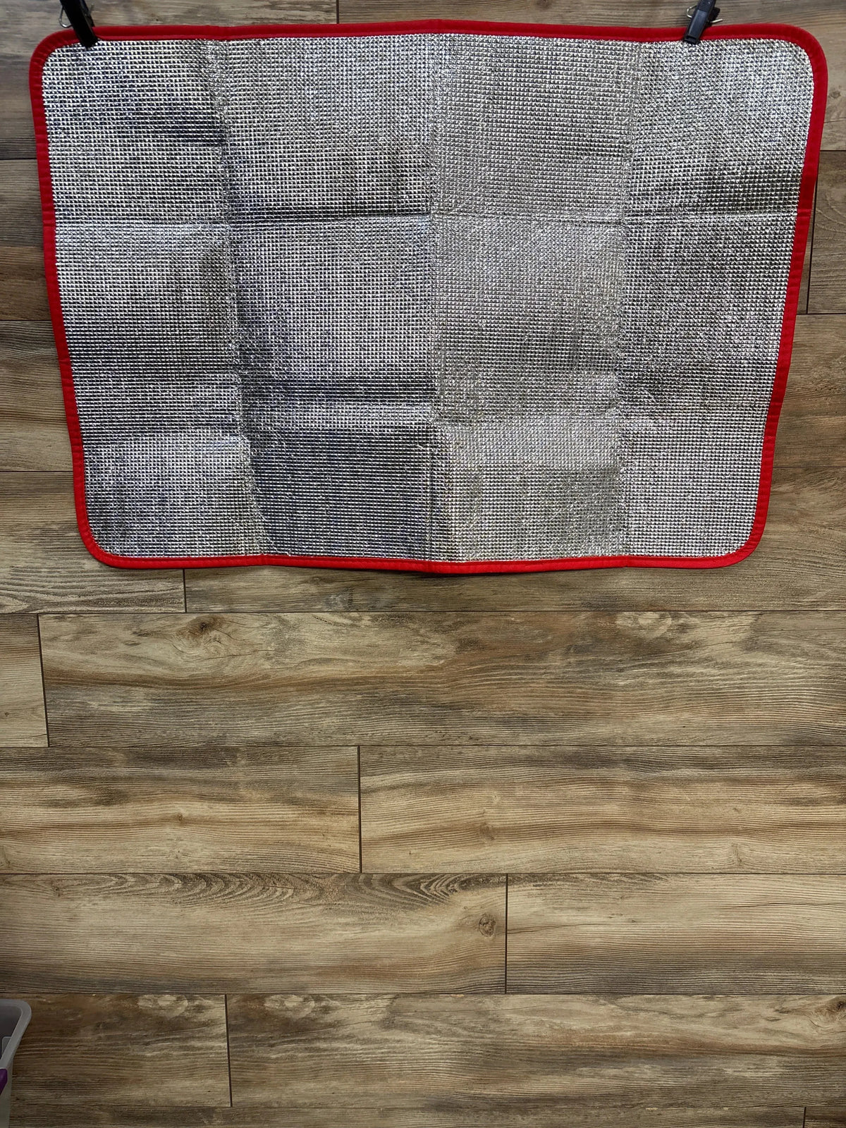 Top-down view of EasyGo Giant Chess 3x4 foot mat showing silver checkered surface and red trim on wood floor