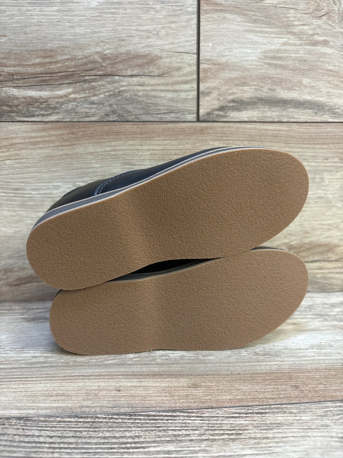 Sole view of NEW Cat & Jack Neal Loafers in black sz 11c showcasing clean unworn tan rubber soles with wood plank background