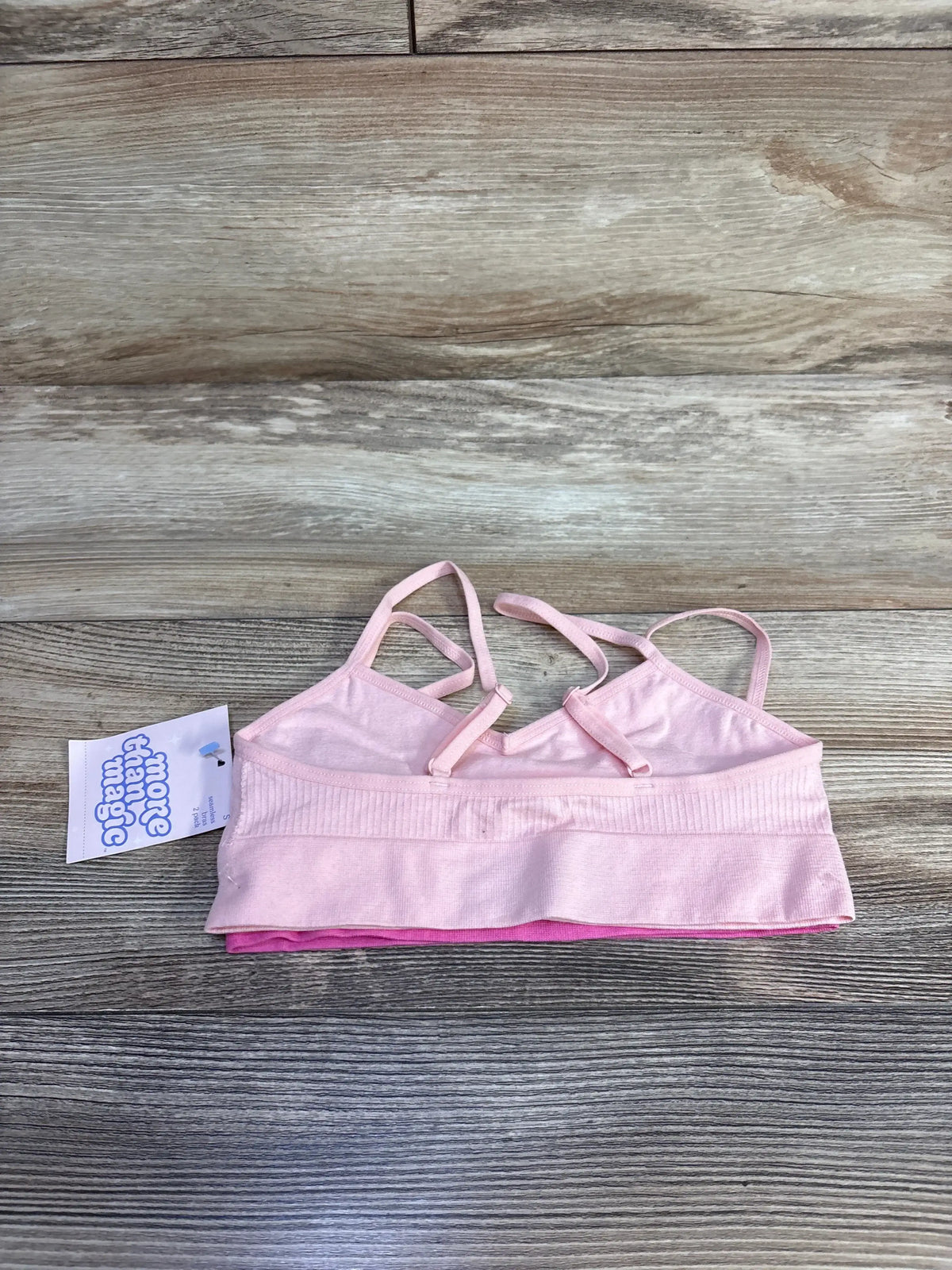 Pink More Than Magic girls' bralette with straps on wood background