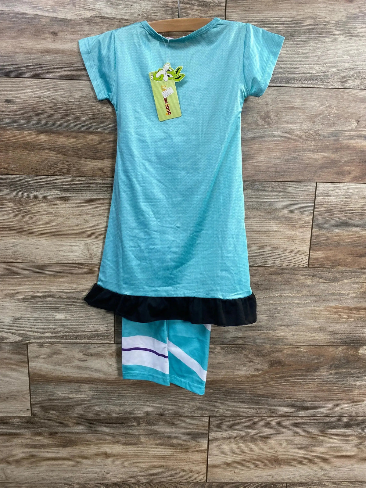 Front view of a turquoise Vanellope costume with black ruffled hem and matching striped shorts on a wooden background