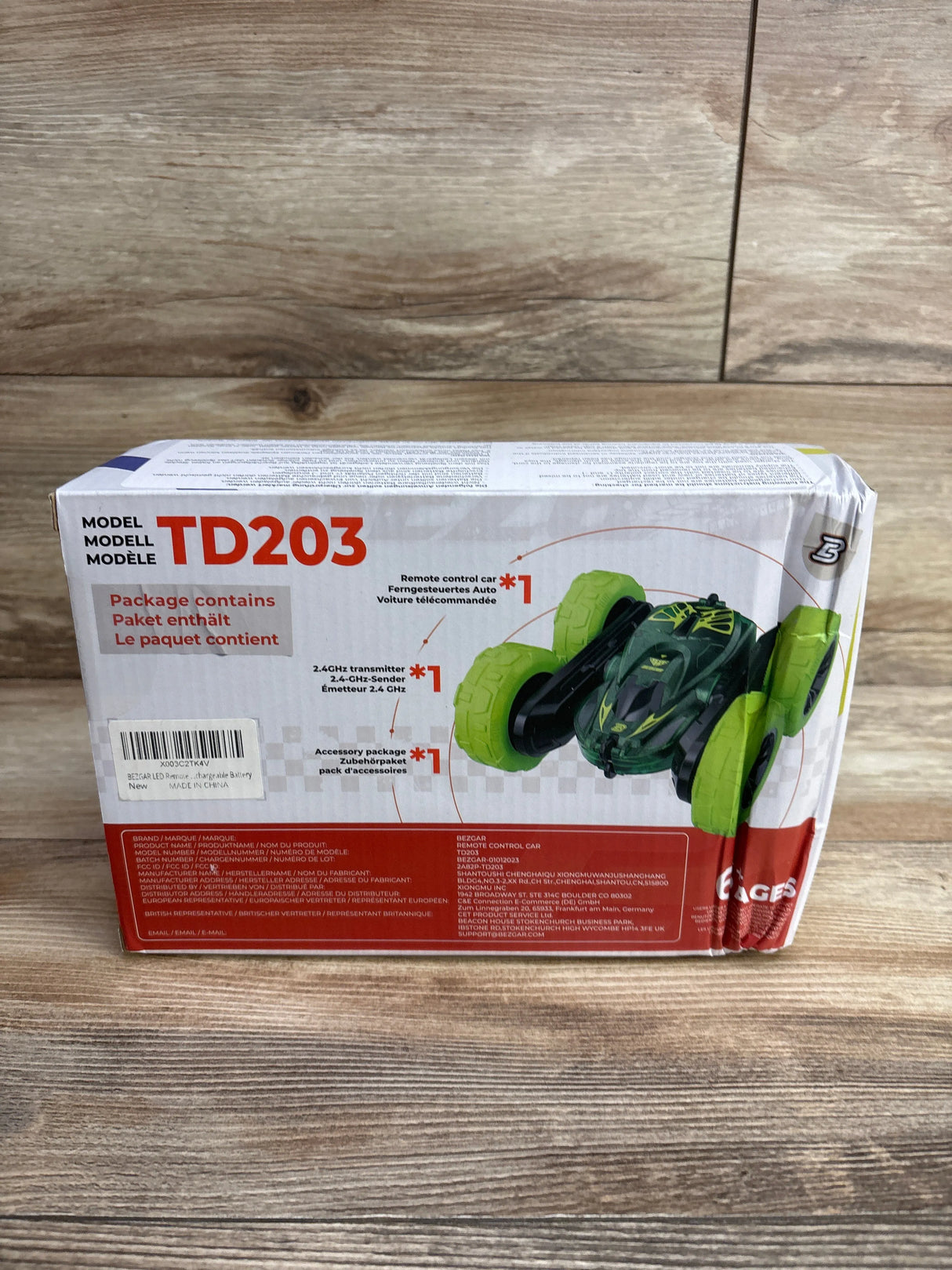 Box of TD203 remote control car with bright green wheels and black body, includes transmitter and accessories