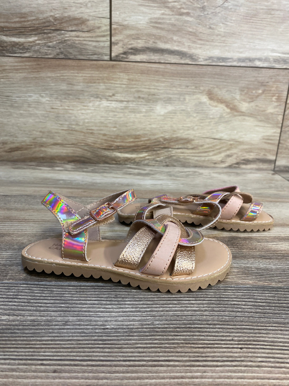 Girls’ iridescent strappy sandals with glitter and buckle on wooden floor