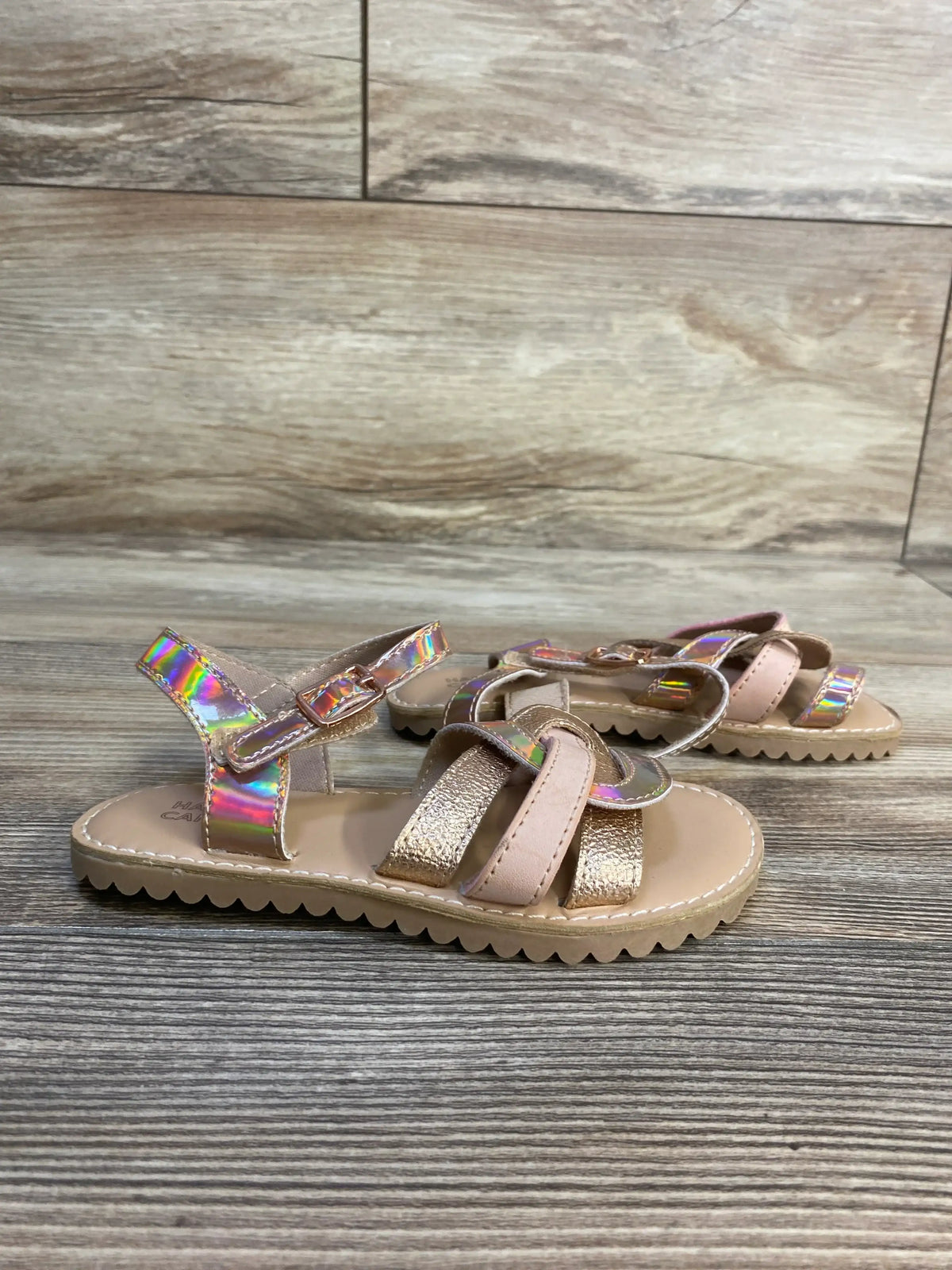 Three-quarter view of Harper Canyon Finley strappy sandals in tan showcasing iridescent and gold straps with wood plank background