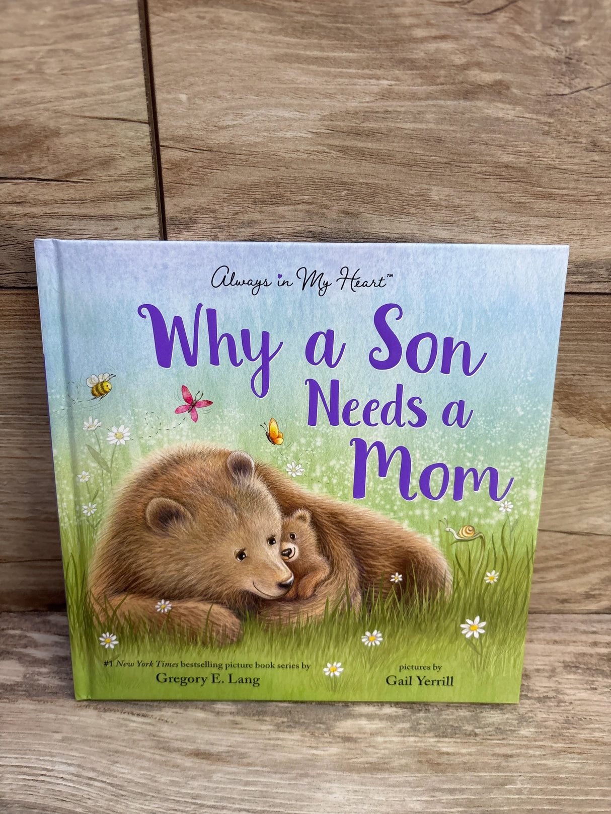 Why a Son Needs a Mom book cover with bears, grass, and flowers on wood background