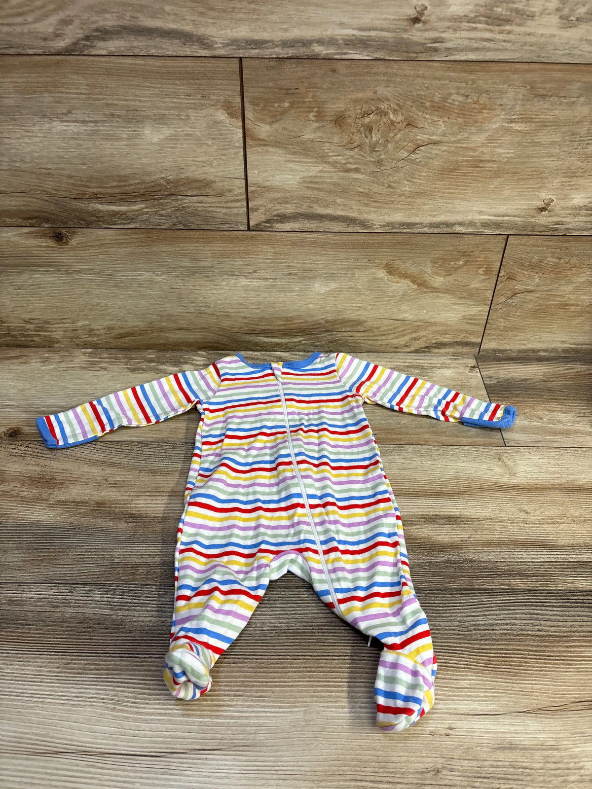 Front view of Wonder Nation white striped sleeper for ages 0 to 3 months with a front zipper on wood flooring