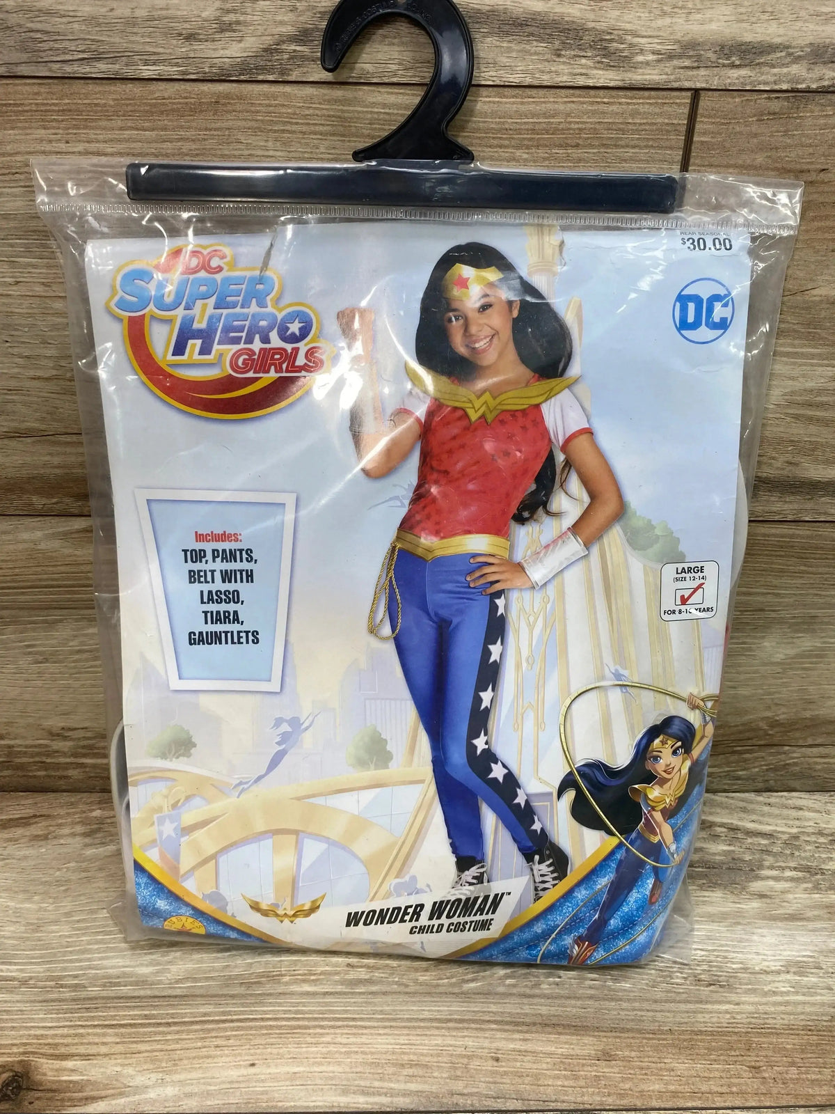 Front view of Rubies Wonder Woman costume package showing top, pants, lasso belt, tiara, gauntlets, and size 12 to 14 label