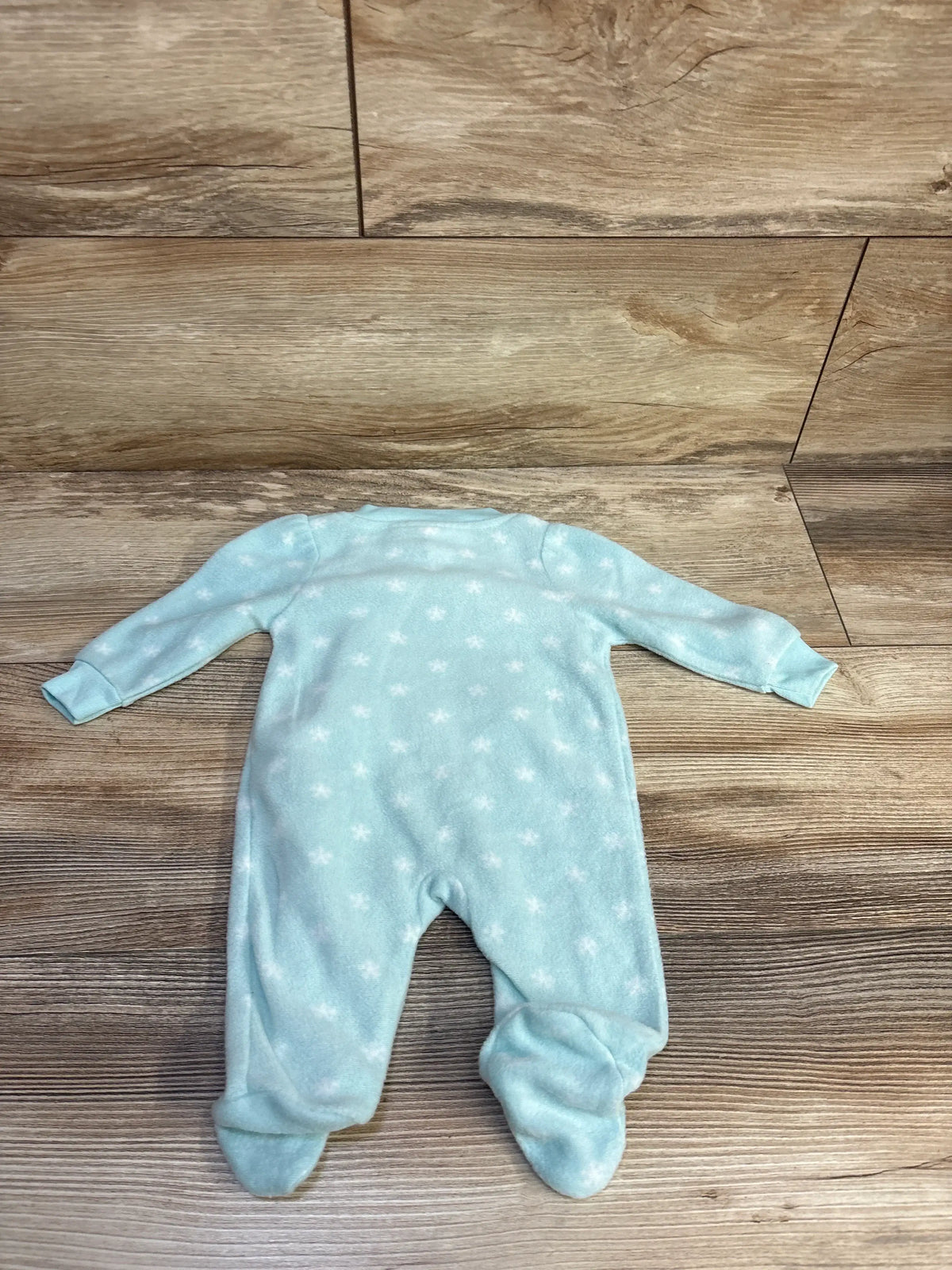 Front view of blue Koala Baby newborn blanket sleeper showcasing white stars, long sleeves, and covered feet on wood floor