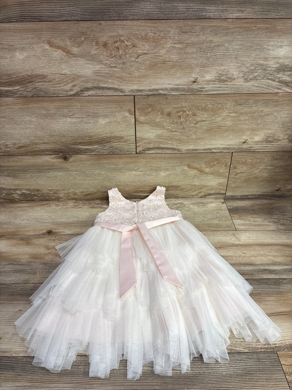 American Princess pink layered tulle sleeveless dress with satin bow on wood background