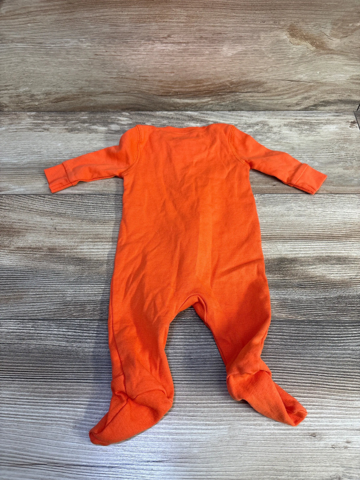 Primary Organic solid orange newborn sleeper on a grey wood background