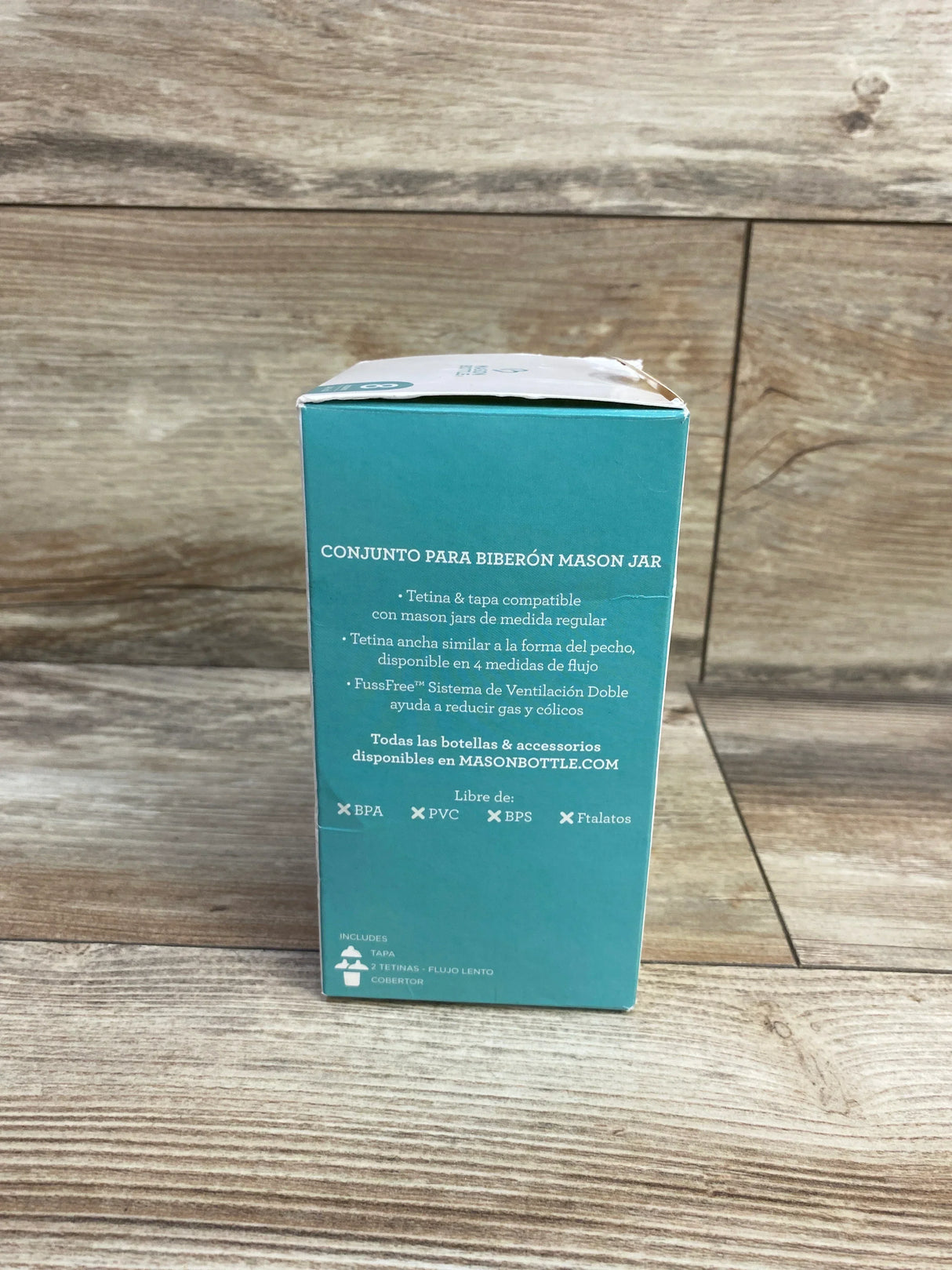 Back of Mason Bottle 8oz glass baby bottle kit box showing cap, two slow-flow nipples, and silicone sleeve on wood