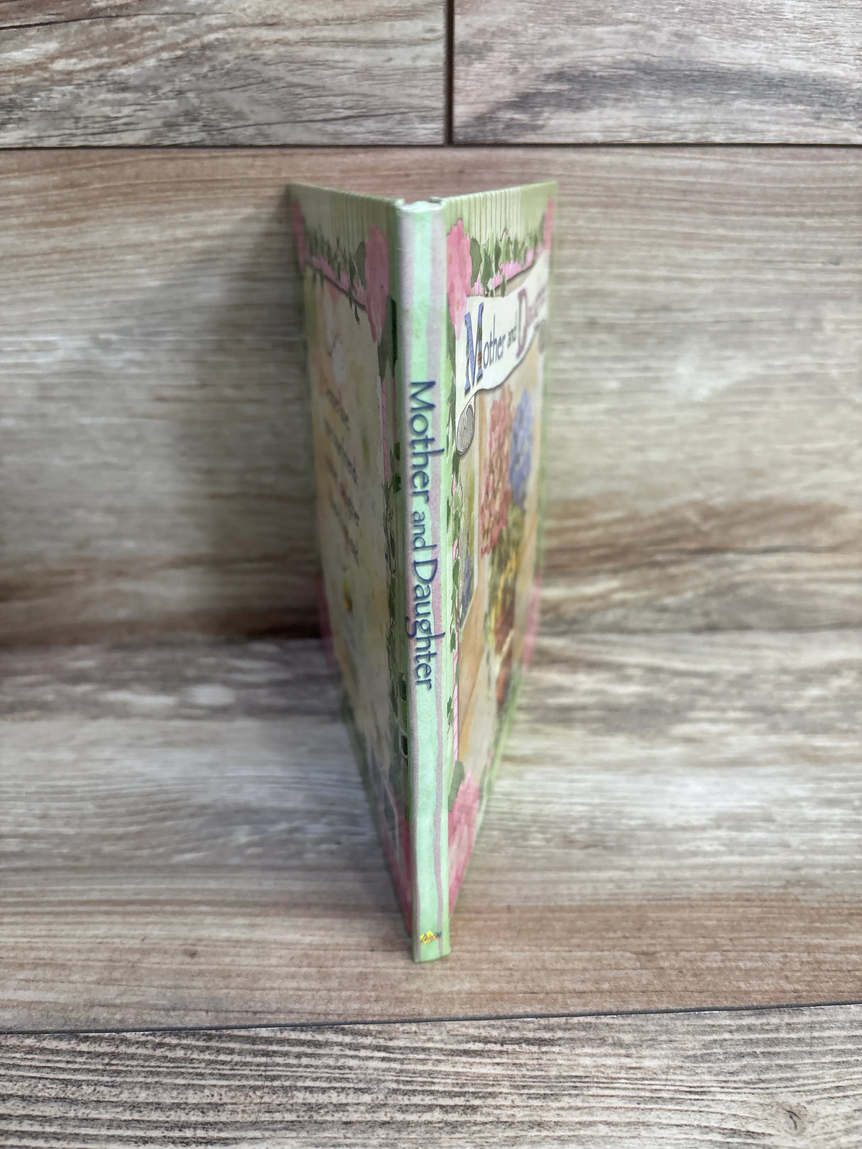 Mother and Daughter book with floral cover standing upright on wood surface